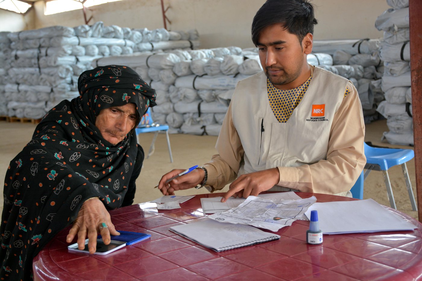 Gul Ghotay puts her finger prints at the bottom of paper to receive a tent from NRC in Qala-i-naw.
Gul Ghotay, a widow lives with her two daughters and a son in Feristan IDP settlement. Her husband died five year ago. Her oldest son is separated and living in Herat with his family. Her second son has become an opium addicts and she doesn’t know about his fate anymore. Zalmay, 17, her youngest son and her lost hope has been affected with Tuberculosis TB in the settlement. The family was living in substandard makeshift home in the river bed of Feristan settlement.
Though Zalmay is suffering from Tuberculosis, but he is the only breadwinner for his family of four. He has recently started selling sandwich in the market.
“we weren’t bothered by heat neither were we cold in our village. We are suffering all the time since we have been displaced. My son was healthy and now he coughs for hours or sometimes he brings out all his clothes and the other time he feels cold and asking me to put all the blankets over him. He acts weirdly and sometimes he doesn’t want to eat for days. The doctors say he has to eat plenty of fruits, vegetables and chicken meat, but the problem is that where can I get those all for him?”
“The doctors in Badghis told us to take him to Herat. We didn’t have enough to take him there. So I borrowed 10,000 AFN (Approx. $140) from my brother and took him there. The doctors give him some medicine and asked to visit them frequently. Now I don’t have enough to take him in Herat or buy him medicine."
Zalmay, 17, is infected with tuberculosis in Feristan IDP settlement where he and his family lived for over five months.
“I felt pain in the chest at the beginning and then was coughing. I didn’t tell my mom unless it got worst. I went to doctor and the doctors said I have been infected with tuberculosis. They gave me medicine for two months and asked me to visit them again. There have not been any changes or progress in my health. I still feel pain in my chest and coughing up blood.”
Photo: NRC/Enayatullah Azad
