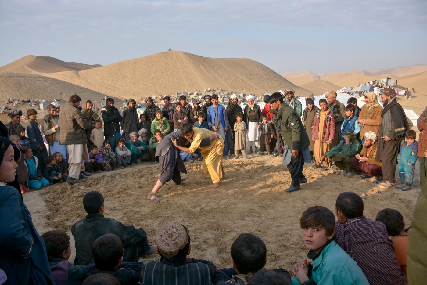 When the sun starts going down the youth are gathering on the hill top just outside the Feristan camp for wrestling. The children are playing marbles during the day and the elders sit outside the makeshift homes, talking and talking for hours. The women and girls are sitting inside or outside their small and overcrowded makeshift tents and sometime prepare food when they have enough firewood.
“Most of us used to work on the agricultural fields and some were busy going to schools and Madrasas. And now, we have nothing to do during the day and no job opportunities at all. The city is also far from here to go and work and I think we are just abandoned here. we are wrestling to overcome the pressures and forget about our loans that we have taken,” said one of the wrestlers.
Photo: NRC/Enayatullah Azad