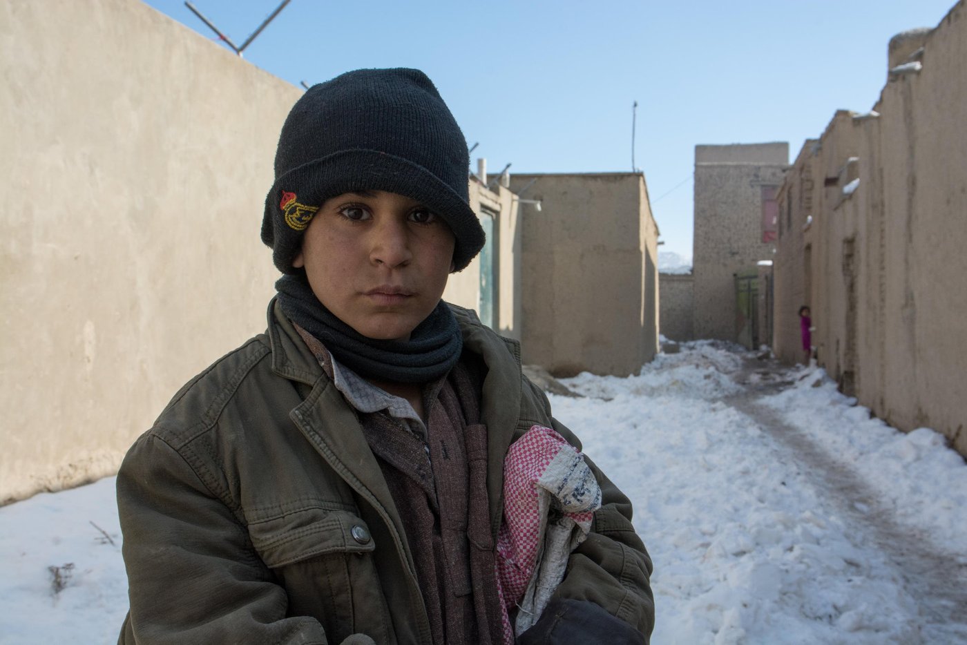 What is your name?
Akhtar Mohammad.
How old are you? 
I don’t know 
Are you going to school? 
No.
Then what are you doing during the day? 
I’m collecting scarps on the streets. 

Akhtar a thirteen-years-old who deals with paper, notebooks and books all the day do not attend the class. Akhtar is an IDP child living in an IDP settlement in west Kabul. He and has family has fled conflict some two and half years ago from Kunduz province. Akhtar has five siblings. He and his father works on the streets collecting scraps. He usually collects Pepsi cans and papers. He sells the cans and brings the paper home to burn to make the house warm and also, to cook food. 
As the Afghan children are very delightful for the first winter snowfall on Friday and are playing and making snowballs; Akhtar has left the home with a bag to collect scraps. Akhtar and has family spent last winter in makeshift tents. NRC with generous support of DANIDA upgraded their shelter to fight against the freezing temperature this winter. Photo: NRC/Enayatullah AzaD