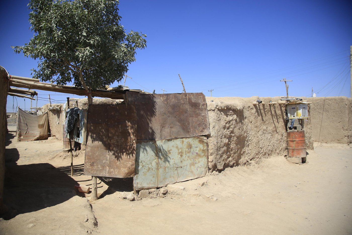 Despite decades in displacement, some Afghan families live in “aloonaks” which have evolved from tents to precarious and unsafe shelters like this one in Badrsir settlement. Photo: Hamid Sadeghi/NRC