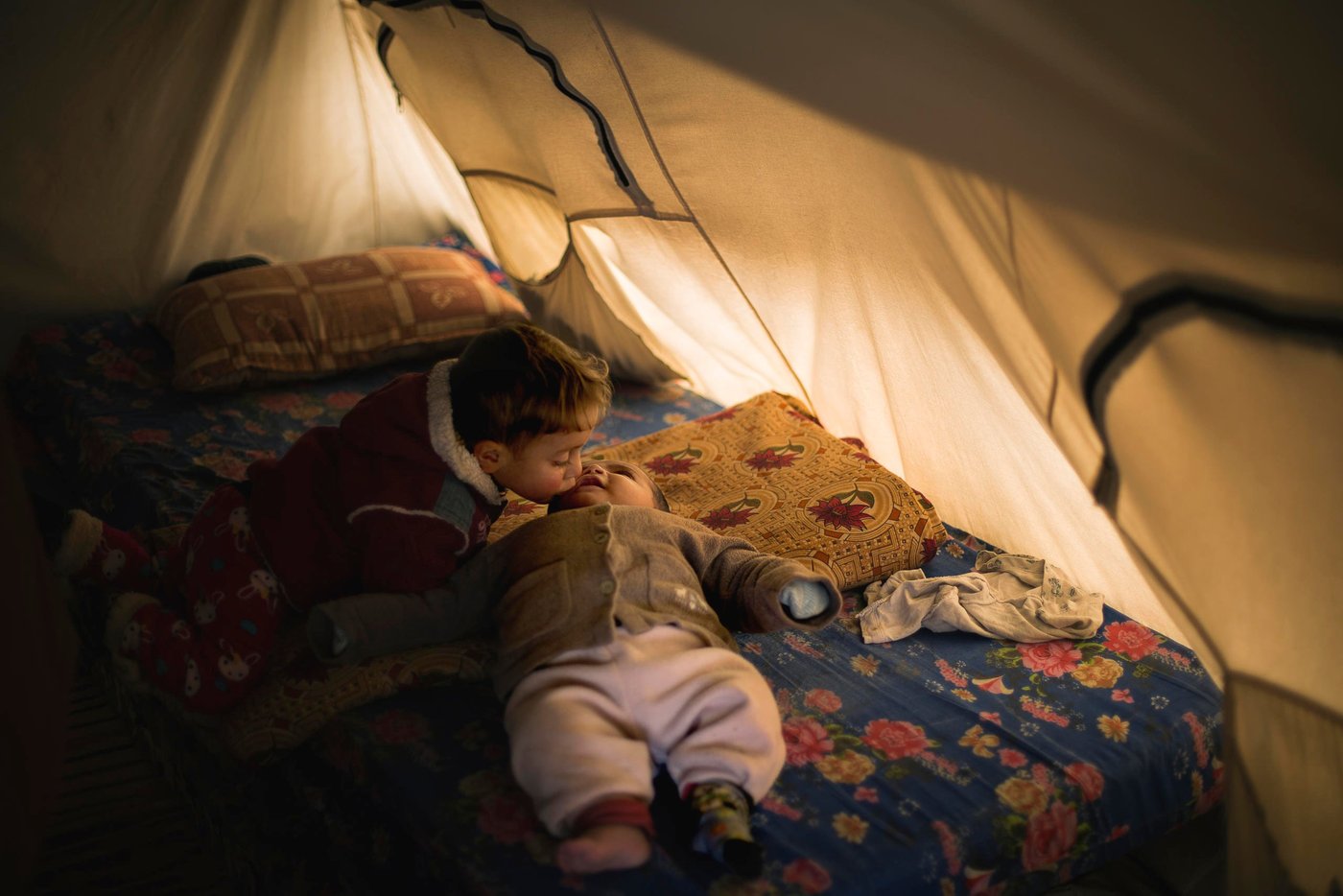 Kinan a (6-month-old) is kissed by his big brother Saif (2).
Kinan has an infection in his Stoma, and needs medical treatment.
Photo: NRC/Hussein Amri