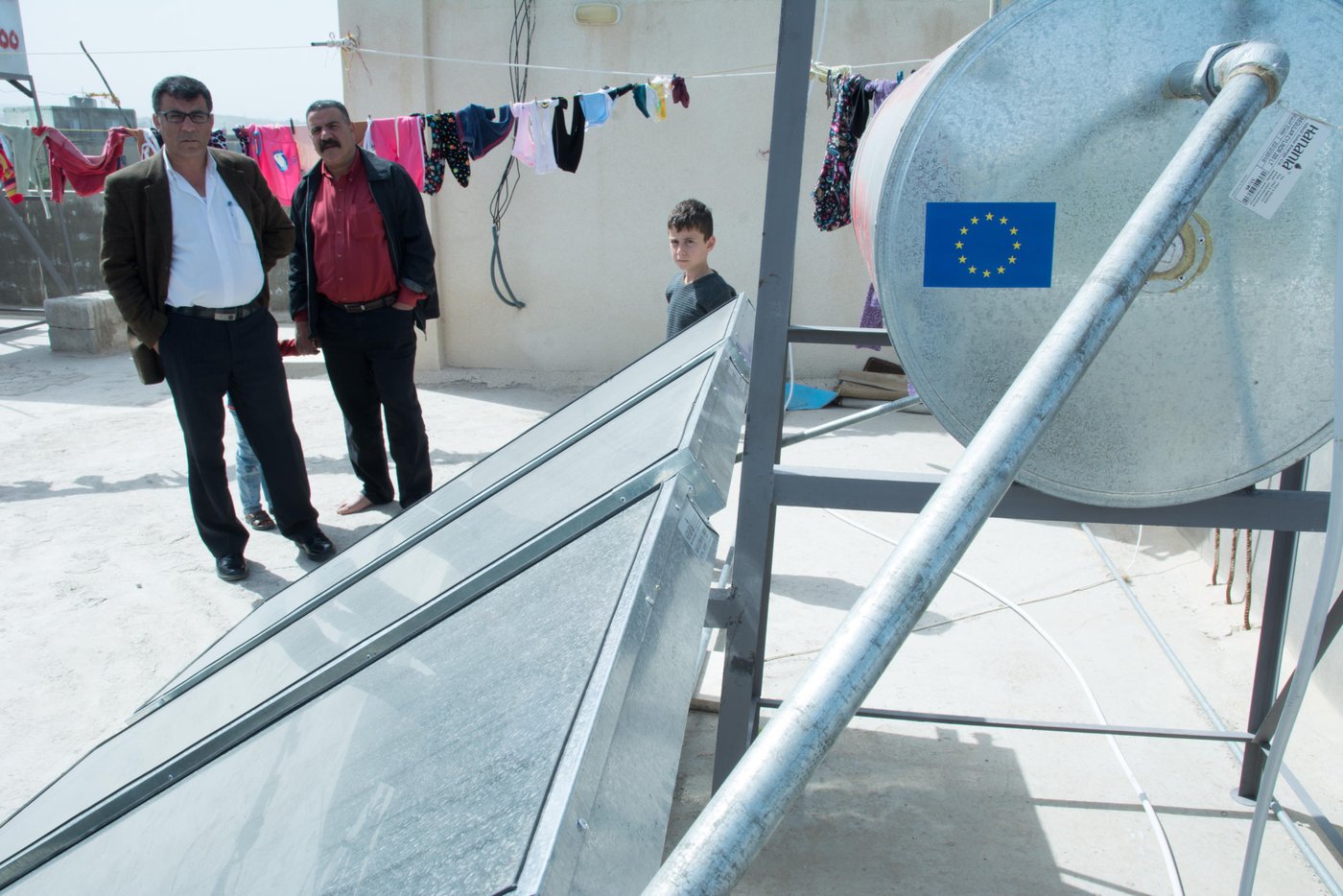 House owner and landlord Emad (left) stands on the roof of the building where he rents an apartment near Irbid in Jordan. As part of a project by NRC, the Jordanian Ministry of Energy and the EU, his tenants, Syrian refugees, now enjoys hot running water from the solar heating system recently installed on the roof.
March 9th 2016
Photo John Cutliffe/NRC