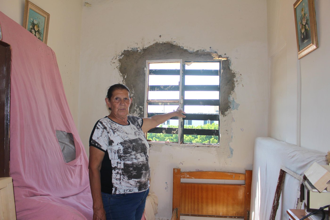 The glass of all the windows were shatterd in Hayat's home in Karantina, one of the most affected areas by the Beirut explosion.
Hayat, 70, is one of thousands of people who were affected by the blast that damaged parts of their homes. She and her two sons with their families live in Karantina, XX km away from the explosion site. They live on different floors in the same three store-building. At the time of the explosion, she was sitting outside on terrace of the building’s rooftop.
“I was sitting on our terrace when the first explosion happened. I thought that airplanes were bombing,” says Hayat. “I immediately ran inside to get some of my key documents and my purse when the second explosion happened. It was so loud and it blew me off the ground.”
“I didn’t know what to do and my first thought was that my sons could not have survived this. Then, I saw my son, Giofar, coming up the stairs calling for me in panic to check if I was okay. The blood was dripping from his head and his body was full of glass shatter,” says Hayat.
“We have lived in this building for 27 years. I have witnessed all the wars and conflicts in Beirut but never have I seen Beirut so severely damaged as this,” says Hayat. “The scene outside our home looked like a battle field, beyond what you can comprehend. People were running around in panic, bodies on the ground, blood everywhere, buildings falling apart, cars under the rubble and glass shatter all over,” she says.
“There is a hospital opposite to where we live but it was totally destroyed and we were not able to move to take my son to the hospital. We lost him in the turmoil but a police officer had seen him injured and took him on his Vespa to a hospital about 15 km from where we live,” Hayat explains. “He came back fully stitched but we are lucky he survived,” she says.
“My other son’s wife was giving birth a few hours before the explosion, she delivered a baby boy. The hospital had to release her after just a few hours just to make space to other people who were heavily injured in the blast,” says Hayat.
“My grandchildren are all traumatized. They are afraid and can’t sleep during the night. Whenever they hear any loud sound they start screaming and fear another explosion will go off. We are constantly worried that something else will happen,” she says.
“We have a lot of needs now, the windows, curtains, and furniture are all damaged. The glass shatters destroyed everything and the walls have fallen down. My kitchen is not functioning and the water pipes are all broken. We need our homes to be repaired urgently but we can’t afford the repairs,” Hayat says. “We don’t know when we will get assistance but we need everyone’s help to rebuild the streets of Beirut,” she says.
“When I look at the destruction around us, I can only say we were saved by a miracle,” says Hayat. “In the end all the material damage can be replaced, we can eventually buy new ones but a life can’t be replaced,” she says.
“Imagine, one of the neighbours in the building next to ours is Syrian. He has been living alone for a while and his family in Syria. A few weeks ago, the situation where his wife and two daughters live in Syria worsened so he brought them here to be in safety and escape the war. But they didn’t escape death, the roof fell over them in the explosion and his wife and two daughters died. If you see him now, it’s like he has gone mad,” she says.
“My husband died when my children were very young and I raised them as a single mother. I put all my heart and effort to raise them and keep them safe. My biggest fear is to lose them now when they are adults. They are my whole life and if something happens to them I wouldn’t be able to handle it. The situation in country has become unbearable. Our hearts are broken, the people are tired and Lebanon has suffered enough,” Hayat concludes.
Photo: Racha El Daoi/NRC