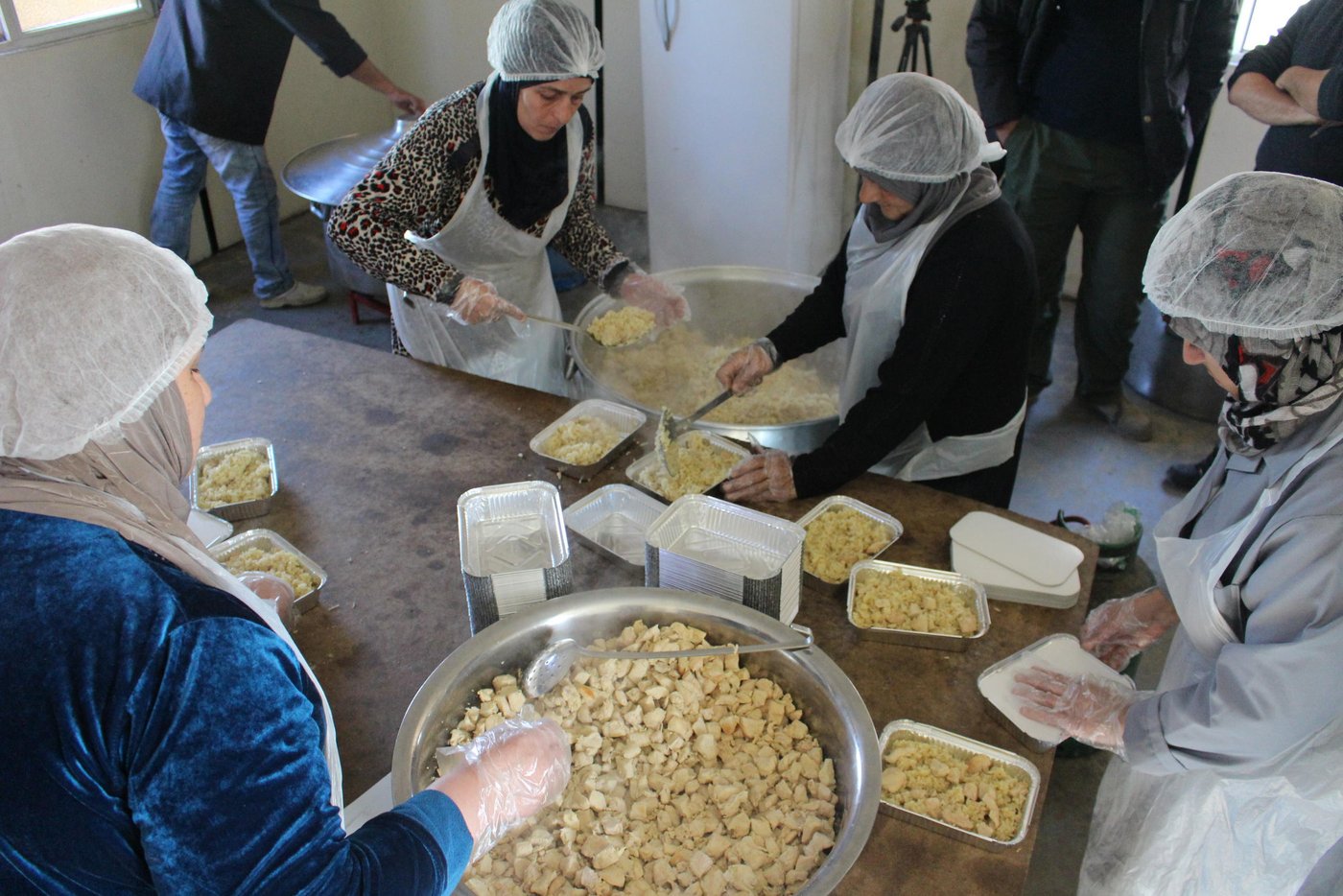 Khitam, a 54-year-old woman from Syria, lives in one of the biggest refugee settlements in Lebanon, together with more than 1,500 refugees. She is one of seven refugee women cooking meals that are distributed to the refugees living in the settlement.
"I work to support myself. My situation is dire and I don’t have anyone else who can provide for me," says Khitam.
Thanks to the generosity of our private sponsors, the Norwegian Refugee Council (NRC) was able to provide funding to a local Lebanese organisation, Union of Relief and Development Associations (URDA), that set up a kitchen in a refugee settlement in the Bekaa Valley in eastern Lebanon. URDA employs refugees to cook the food and distribute the meals to thousands of refugees living in tented settlements.
Fled from Syria six years ago
Six years ago, Khitam fled from Homs in Syria to Lebanon with her husband and children. Her husband died three years later, leaving her alone.
"My children have families and are barely able to feed their own children. I could never ask them to provide for me as well," she says.
She is happy to be a part of the cooking group in the camp.
"Cooking food for other refugees makes me happy and the salary makes me able to support myself. It’s heavy work – we do everything from cutting chicken and boiling rice, to cleaning and preparing food boxes for over 1,000 people."
Over 1,500 meals for 300 refugee families
In March 2019, NRC supported the preparation of over 1,500 meals for 300 refugee families, the majority of whom were evacuated from their homes after the winter storms. Some of them have still not been able to return to their homes as their tents are being rehabilitated.
Khitam and the other women receive a lot of positive feedback from people saying they’re enjoying their food.
Through the cooking, the women come together and are able to keep their mind off their current lives as refugees.
"Knowing I contribute to put food on the table for other refugee families and to feed their children makes it worth all the hard efforts I put into my cooking,” says Khitam.
Credit: Racha El Daoi/NRC