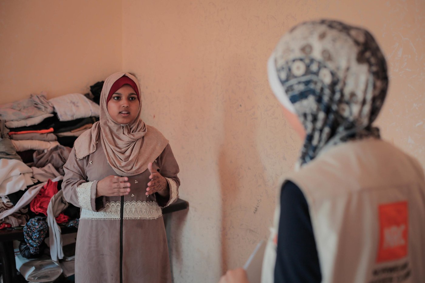 Diana Murad, 18 – Jumana’s oldest daughter – seen here talking to NRC shelter assistant Aya Abu Ramadan in her family’s rented apartment.
Diana sustained shrapnel wounds to her left arm and thigh in 2018 while taking part in the Great March of Return mass protests on Fridays along Gaza’s perimeter fence with Israel.
In March this year, a tear gas canister struck her in the right shoulder. While Diana’s father looked for her amid the crowds, he fell to the ground with a bullet wound to the leg. Complications arising from diabetes and kidney problems have stalled his recovery.
Photo taken on 21 August 2019
Photo: Ahmed Mashharawi/NRC