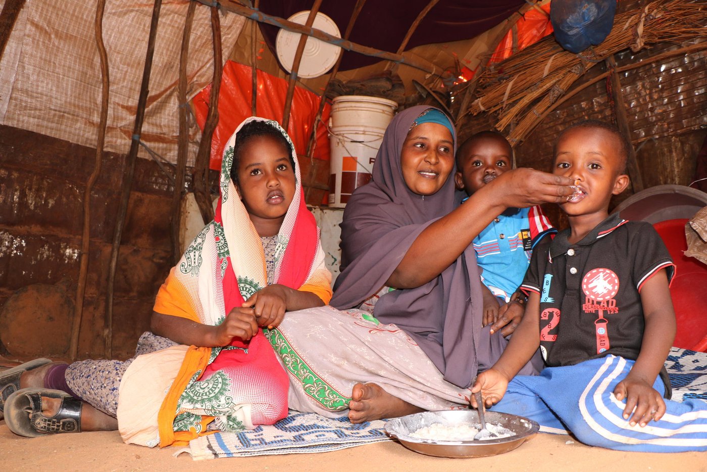 Effects of combined crises - droughts and locust infestation
Recurrent droughts and locust infestation have had negative impacts on the livelihoods of vulnerable communities leading to severe humanitarian situations in many parts across Somalia. One of the major effects of drought is displacement, people are forced to move from drought-affected areas in the rural villages to urban and semi-urban areas to seek humanitarian assistance and better livelihood opportunities.

Ayan Mohamed Said is a 37-years-old mother of three children, two boys and one girl. She is currently one of the internally displaced persons living in Lebigun village in Burao district, Togdher region. Before the drought, life was good for Ayan and her family. She had a large number of livestock (camel, goats and sheep), but sadly everything changed when the drought hit their areas and destroyed all their livelihood sources.

They lost all their livestock due to lack of water and pasture. Ayan and her three children walked long distances to reach Lebigun village in search of food and shelter. “We were pastoralists, our livelihoods were mainly livestock. The drought has decimated my family’s livestock holdings and put my family at risk of severe hunger. I was not able to feed my children. I remember several nights when my children went to bed without eating,” she said.

Ayan continued “Our situation was getting worse and worse. We became hopeless, and as a mother, I couldn’t watch my children starving day in day out. I decided to move to the urban areas in search of food. We finally reached here (Lebigun village in Togdher region), where we could barely scrape a living through the small assistance received from our relatives.”

Multi-purpose cash assistance.
Ayan is one of the beneficiaries of NRC’s life-saving assistance project in Togdher Region which is generously funded by the German Federal Foreign Office (GFFO). She was amongst 500 drought-affected families who received monthly cash assistance of $85 for a period of four months. This assistance significantly improved the living conditions of Ayan’s family. She used to receive the cash through her mobile phone each month from the Norwegian Refugee Council (NRC). Thanks to the German government, who provided an unprecedented amount of humanitarian assistance in Somalia.

“The cash assistance allowed me to sustain my family’s basic needs. I was able to buy food, medicine, household items, and a goat to milk for my children. The cash also enabled me to pay off debts that I had incurred from food costs at the onset of the severe drought,” explains Ayan.

She also, said “If you have cash, you can buy whatever you want. You can buy 3-4 items at the same time. The cash allowed me to buy what I needed most. For me, one of my key priorities is to buy milk for my children. Our situation is now getting much better. We have food in our house. My children used to sleep on the ground, but now they are sleeping on a mattress. Thanks to NRC and the German government for this life-changing support.”

Drought-affected families like Ayan, who lost all their livestock during the drought, will take quite some time to recover and get back on their feet again, but the cash assistance was a lifeline for them that has addressed their basic needs with dignity and flexibility. The cash has also added value to local trade in areas where markets were functioning, even during the drought.

Text: Abdulkadir/NRC
Photo: Abdulkadir/NRC