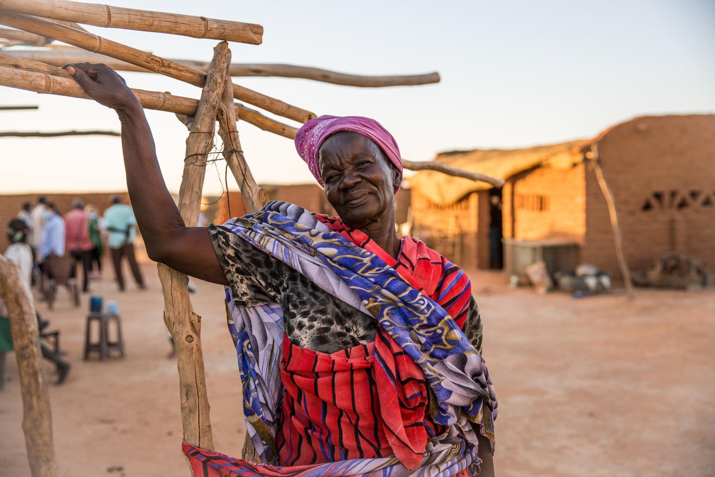Apuk, 70 year old grandmother in her home.
Full story:
Anglo Woku never imagined he would be considered a refugee in Sudan in his twilight years. Especially since he left the Southern part of the country for a better life almost 50 years ago.
“I escaped in 1969, shortly after the civil war broke out. I ended up in Khartoum. I was working for the military. I was married, had a family and friends. Sudan gave me a good life,” he said.
The conflict between North and South raged on for 22 years until a peace agreement was brokered in 2005. Then in 2011, the people of the South voted for independence and South Sudan, the world’s youngest nation, was born.
This new dawn however caused all sorts of legal uncertainties for the South Sudanese living in Sudan, particularly in the years following independence.
“I lost my Sudanese identity,” Anglo, 78, explained: “I went from being a public servant to a refugee.”
In 2011 following the independence of South Sudan, Sudan passed laws that had a detrimental impact on the identity of people with Southern heritage.
They automatically lost their Sudanese nationality and were now considered South Sudanese. Even their children, despite being born and raised in Sudan, were given a new nationality. Many people had no intention of returning to South Sudan, a country, largely unknown to them and this created a legal dilemma on questions around their legal status.
Under the Four Freedoms agreement signed in 2012 between the government of South Sudan and Sudan, South Sudanese were to be granted freedom of movement, residence, economic activity and the right to acquire and dispose property. They were also awarded prima facie refugee status, however the legal status of those who lost their Sudanese identity following the cessation, but with no intention of returning, remains unclear.
Some however made the decision to leave for South Sudan both spontaneously or with the assistance of the UN through facilitated returns.
As part of the organised returns, those willing to repatriate were assembled at departure points. However, in 2013, conflict erupted in South Sudan and the operation was stalled leaving thousands of South Sudanese in limbo and stuck in departure points, to this day.
These departure points, now known as Open Areas, are home to over 31,000 South Sudanese living in nine Open Areas across Khartoum. Anglo is among those languishing in these areas with no rights or access to a decent standard of living.
While registration efforts continue, it is estimated that there are around 154,700 refugees living in nine Open Areas including Um Badda, Jabal Aulya and Sharq El Nile across Khartoum state. They make up approximately 55 per cent of the overall South Sudanese refugee population and are among the most vulnerable members of Sudanese society.
Life is tough in the Open Areas and thousands have limited access to food, water, healthcare or livelihoods.
“I found myself jobless and homeless with no rights, no identification and I have been here ever since,” Anglo revealed further.
Fondly known as ´the Sultan´, the name given to well-respected leaders in the community, Anglo went from the upper echelons of Sudanese society to being exiled to a dusty, sparce flat land called Nivasha on the edge of Khartoum’s city limits.
He and thousands more live an invisible existence here, virtually hidden from the rest of the Sudanese population who struggle on with life in a country buckled by years of oppression, debt, government corruption, international sanctions, recurrent drought-related famines and humanitarian chaos. Out of sight and out of mind seems to the policy for urban refugees in modern day Khartoum.
“I did not want to become a refugee. I worked hard as a citizen but this happened. My children have moved back to South Sudan, but my wife is here. My children have jobs and they are safe. We had planned to move back there but there is no way out now. I have no money and we are struck here.”
Like several others, Anglo is a trapped in an administrative quagmire that no organization or agency has the full funding, capacity or support to resolve.
The Commission for Refugees is the body mandated to manage refugee affairs in-country including registration and refugee status determination. It is funded by UNHCR, which maintains a supervisory role, is currently dealing with a backlog on registration. Access to documentation remains a key challenge for all unregistered refugees. Biometric registration is ongoing however it will take time before the backlog is cleared.
The winter sun is setting as we arrive at Nivasha settlement and paints a golden syrupy hue over the far out and forgotten community.
Terra cotta-coloured cuboid homes line the vicinity like blocks on a Tetris game. Curious heads peep out from glassless windows of makeshift shops, indicating some market infrastructure but nowhere near enough to serve the disadvantaged population.
Bells tinkle from under the throats of overburdened donkeys carrying the only available water to the residents. A teenage boy rides on top and raises his thumbs to smile as the camera flashes and lights up the expansive area that will soon be in plunged into darkness.
There is limited electric, running water, and food scarcity plays constantly on the minds of mothers desperate to feed their growing children.
“There is no food,” said 70-year-old grandmother Apuk.
“We are constantly hungry. I have never known hunger until I came to these settlements,” she said.
A handful of local agencies including WFP offer humanitarian assistance to the 11,000 people of the settlement but there are virtually no income-generating activities available to provide a sustainable away from a reliance on aid.
As a result, many residents venture into the nearest neighbourhoods or markets for daily work opportunities. Men find casual labour while the women find cleaning or housekeeping jobs.
“My daughter when she gets work, provides around 50 Sudanese pounds per day (less than a dollar). If we get money, we get a meal once a day. But if she finds no work, we have to search for food in the night to ensure the children get something to eat,” Apuk said.
“We often come home with nothing.”
Like many vulnerable communities around the world, the Covid-19 pandemic has had a crippling economic effect on people fiercely reliant on daily labour wages.
Restrictions and lockdowns forced the city to close and dried up the only work opportunities available to men and women living hand to mouth. The cash-dependent people of Nivasha are no different to the cash-dependents of Naples, Nairobi or New York. Pandemic poverty affects all.
With no adequate health or sanitation facilities around, Nivasha is a welcome host for coronavirus among other diseases. And if anyone is sick, there is no ambulance to take them to a hospital. The nearest hospital is miles away and the only way to travel is an expensive and unaffordable taxi or motorbike ride.
With the recent inflation rate, certain food commodities such as red meat, dairy products and fish are also expensive. Everything is expensive in economically-fragile Sudan.
As Anglo points out, people need more than subsidies to be able to afford to eat, they need opportunity.
“This land is good. It can be productive for food with the use of small backyard land, but the community does not have the support to start food production activities,” he explained.
“If they had their own vegetables, they could eat them and sell them. There are many women here that are farmers. They know what to do. They would like to start farms or shops.”
Apuk reveals that she grew up on a farm in South Sudan and remembers her young life well.
“We had a good life. We had food, plenty to eat. We were fishermen. I miss the taste of fish, I used to eat it every day,” she smiled.
“I feel safe in Sudan but I just want my children to eat. I want them to have some life. I am old but they are not. I have lived and worked in Sudan, but I would like my community to live better,” she said.
Anglo admits life is not what he expected it to turn out but finds comfort in the many friends he has found in the community. As he talks, several men of various ages gather around him in a brotherly circle. “He is a good man,” says George Allam Lolika-Khalil, the Sultan of another camp, “he cares for the community. He tries to make things right for us especially the children.”
Anglo believes that with the new democratic government, Sudan has the potential to grow but he would like to see the refugee community better served and no longer forgotten.
“If they don´t provide livelihood opportunities or training. We will just waste away. We are now known as refugees but many of us have lived here all our life and we just want to continue living without struggling. We just want to feel settled in the country we have always called home,” he said.
Photo: Ingebjørg Kårstad/NRC
Photo: Ingebjørg Kårstad/NRC