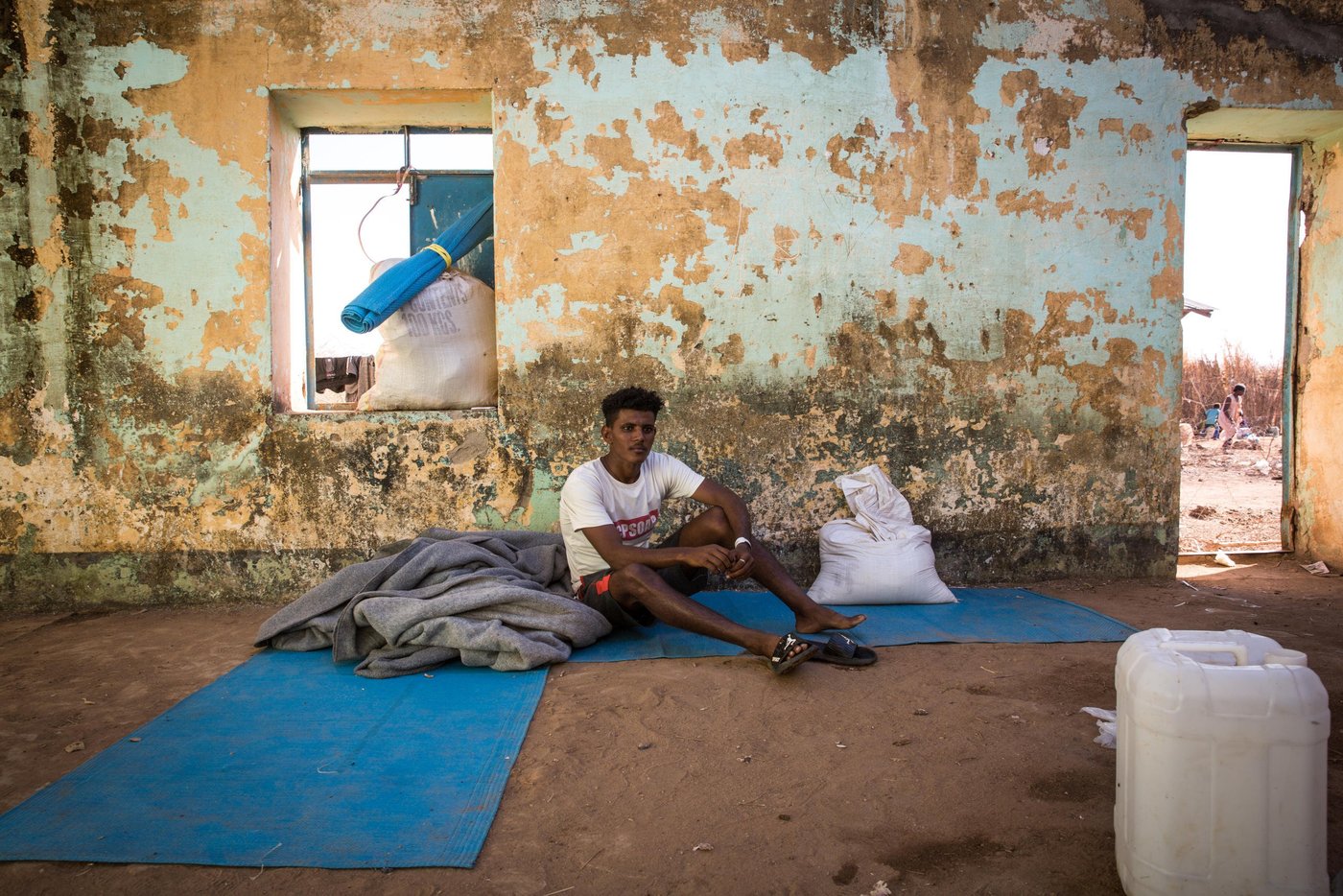 Ashenafi, 19 years old, fled alone from Ethiopia and has not heard from his family since then. He arrived two weeks ago and lives with 14 other people in what used to be a school from when the camp was last open and hosted Ethiopian refugees during the big famine in the 1980s. The roof is partly missing and the living conditions are dire.
"I saw they were killing young men, so I fled. Here I feel safe," he tells NRC.
Photo: Ingebjørg Kårstad/NRC