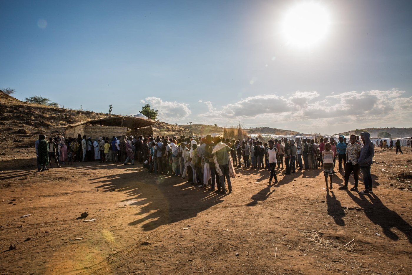 Long lines of people are waiting outside the NRC office in Um Rakuba camp. 

Most of the refugees waiting are young men, which makes up a majority of the ones who have fled Ethiopia.  We were told stories of fear of recruitment to the militia, or of being killed if suspected to belong to TPLF. 

Photo: Ingebjørg Kårstad/NRC