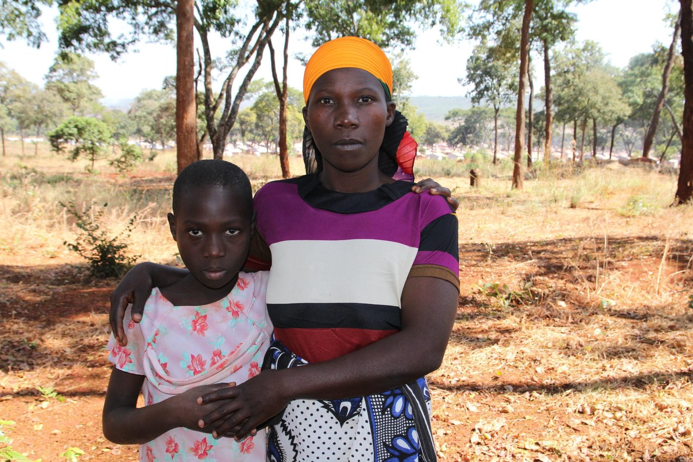 The name ‘Imbonerakure’ sends cold shivers down the spine of Josiane, as she remembers how they took away her husband on that fateful night. Imbonerakure is the name of a local militia group in Ruyigi Province of Burundi that is known for abductions and gruesome killings of its victims.
“It was around 11pm. We were sleeping in the house. Suddenly we heard commotions outside. Some people had surrounded our house. A man called my husband’s name and demanded that he steps outside. He obliged. “You thought we were joking,” another man was heard saying. They grabbed him and dragged him into the darkness.
Josiane’s husband was a mason, while she was a farmer. They were living in good houses. They cultivated cassava, beans and vegetable. They had bought the land that they lived on. All this changed after this incident.
She was traumatized. Fear was her daily companion. Two days later, she packed her bag with clothes, took her children and left the village. They traveled at night to avoid being obstructed. They walked all the way to the Tanzanian border. It took her five hours to reach the border.
Intially they were about 60 people walking, a large crowd of desperate souls. But this worked to their disadvantage when somewhere along the road they were attacked by bandits and forced to surrender all their belongings and money. Afterwards, people opted to split and walk in smaller groups of five to ten. When they reached the border they were only eight.
Children in conflict
“The children, especially Diane, are very alive to everything that was happening, they know when there are problems. They are capable of detecting feelings and moods around their villages,” says Josiane. She narrated that following the abduction, the children could not stop crying. They urged their mother to leave the area and take them to a safer place.
After the journey to Tanzania, the children were falling sick. They were also suffering from complex psychosocial trauma. Josiane recalls incidents where her children felt that all was lost and life had taken a turn for the worst. Feelings of nostalgia, remembering the days when their father used to buy clothes and food brought tears and pain. They complained of living in tents with no light. They were very depressed. Meanwhile Josiane has her own psychological wounds to heal. She misses her husband and the quiet home life of yesterday. These are wounds that the eyes cannot see.
Any good thing inside camp? She acknowledges that while life is harsh, at the least they are able to receive food rations to keep them alive. In addition, except for domestic squabbles between neighbours, the refugee camps are relatively peaceful. There are no marauding militiamen killing men and abducting children.
How important is education to her? “Whenever there is education, children prosper. They get the support that they need to grow. Education provides new opportunities for literacy and numeracy as well as employment for young people,” she says. Her fourth born daughter, Diane (10), left Burundi while in Class Three at Kumwumi Primary School. However, while at the camp, Diane has not been able to resume school. She lacks the basic learning materials. “She lacks clothes, shoes, books, pen, ruler and a school bag,” she says.
However, Diane is excited about the prospect of returning to class. She is one of the pupils who will start schooling at the primary school being constructed by NRC in Mtendeli. “They frequently walk to the construction site to see how the work is progressing. It is a clear indication of their level of excitement,” says Josiane.
The school is being built near her home. This means that Diane will not have any challenge going to school. Diane likes Kirundi language and Mathematics. She misses her father, her home, her friends, her school and one teacher who used to tell stories in class. She hopes to make new friends and meet new teachers.
Multiple displacement
Josiane is not a stranger to displacement and being a refugee. She has been displaced from her home three times over her lifetime. However, the latest incident is by far the most traumatizing. She was first displaced in 1994 following the assassination of the Burundian president and the genocide that ensued. During that incident, she fled Burundi to Tanzania and settled at Mtendeli. Her second displacement happened in 2003 following deadly tribal clashes mostly targeting the Hutu community. Again she fled to Tanzania and settled at Karago refugee camp. The current situation marks her third displacement experience.
Never going back
Josiane is never going back to Burundi. She was highly traumatized by the abduction of her husband. She wants her daughter to grow up and become a successful woman. But she does not wish for her to return to Burundi. “She is better off living in Tanzania, or a third country, but not in Burundi. That country is built on an unstable foundation,” she says.
Photo: NRC/Ingrid Prestetun