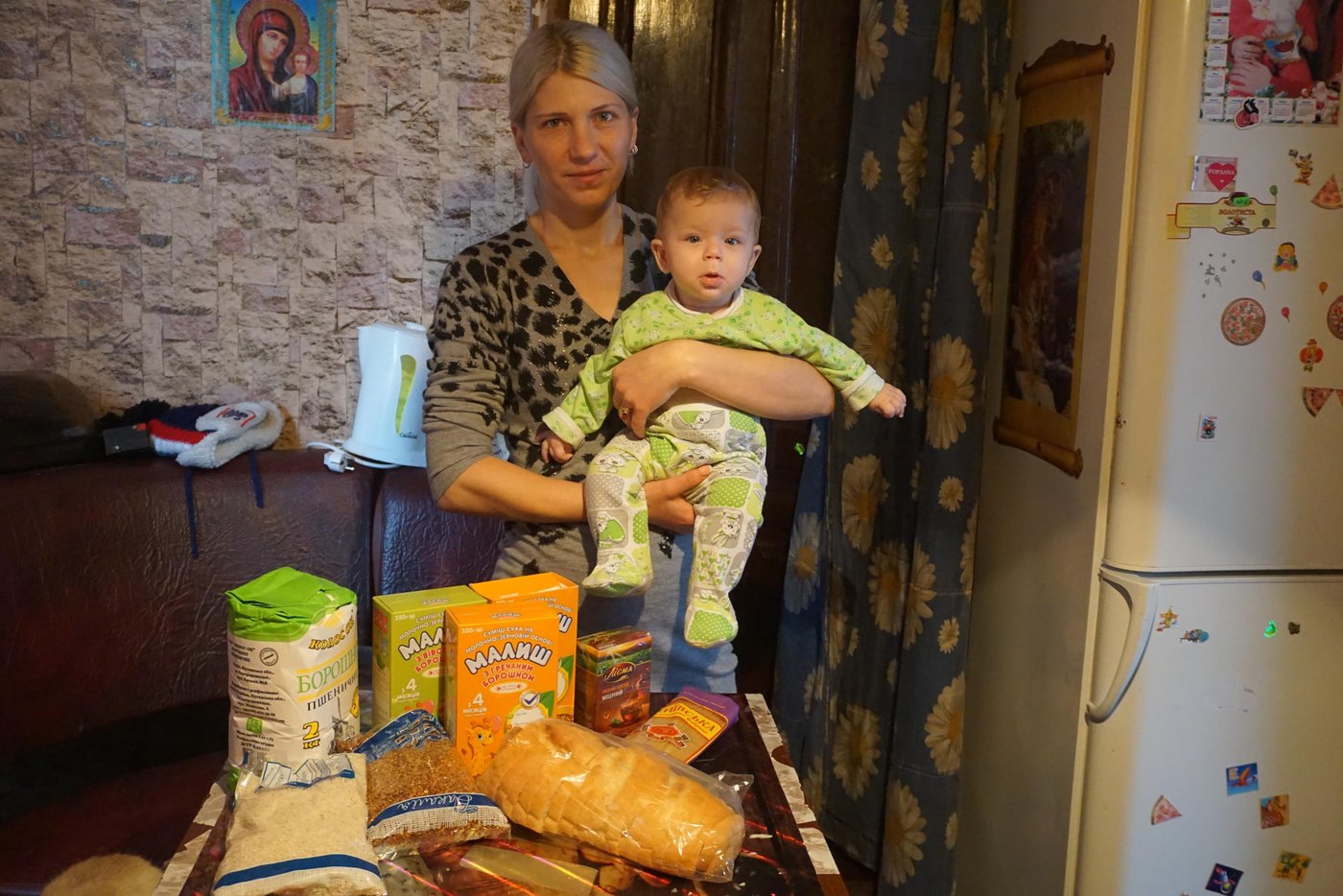 Oleksandra Zahvodska, 32, lives in the frontline Popasna town in Luhansk oblast, she is a mother of 3 minor children. “My husband has passed away two months ago. Now I am the only breadwinner in a family. But I cannot work as my youngest daughter is only 6 months,” says Oleksandra. She looks into winter with fear and uncertainty, with quite small childcare allowance she should provide for her children and heat her house. Her house does not have central heating, she uses firewood to warm it. “For a season I need nearly 8 cub. meters of firewood, which is also costly for my family”. Recently Zahvodska received cash assistance from NRC, which will cover her family food needs for cold season, and she will spend her savings for the fuel.
Photo: Anastasiia Karpilianska/ Norwegian Refugee Council