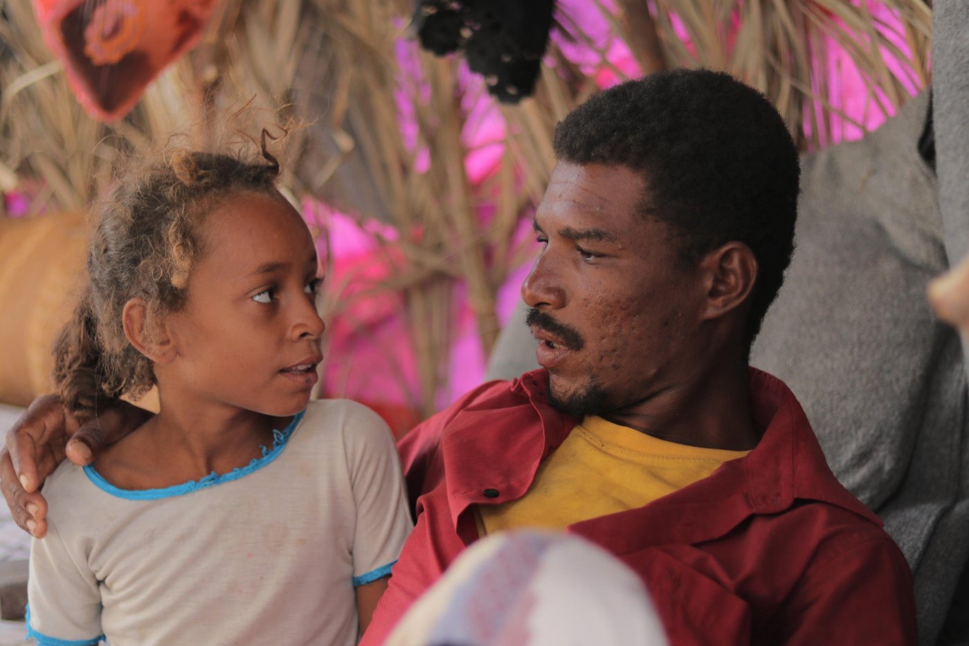 Taha Ali Salem Shamal and his daughter. Taha, 27, was forced to flee his home with his wife and three children. They fled to Al-Khawkha district in early October 2020 and are now staying in Al-Gasha camp, where some other displaced families are seeking shelter. Taha doesn't have a good shelter here, but safety is the most important thing for him. He collected wood and was given some plastic sheets from other displaced families who helped him to set up a tent.

Photo: Mahmoud Al-Filstini/NRC