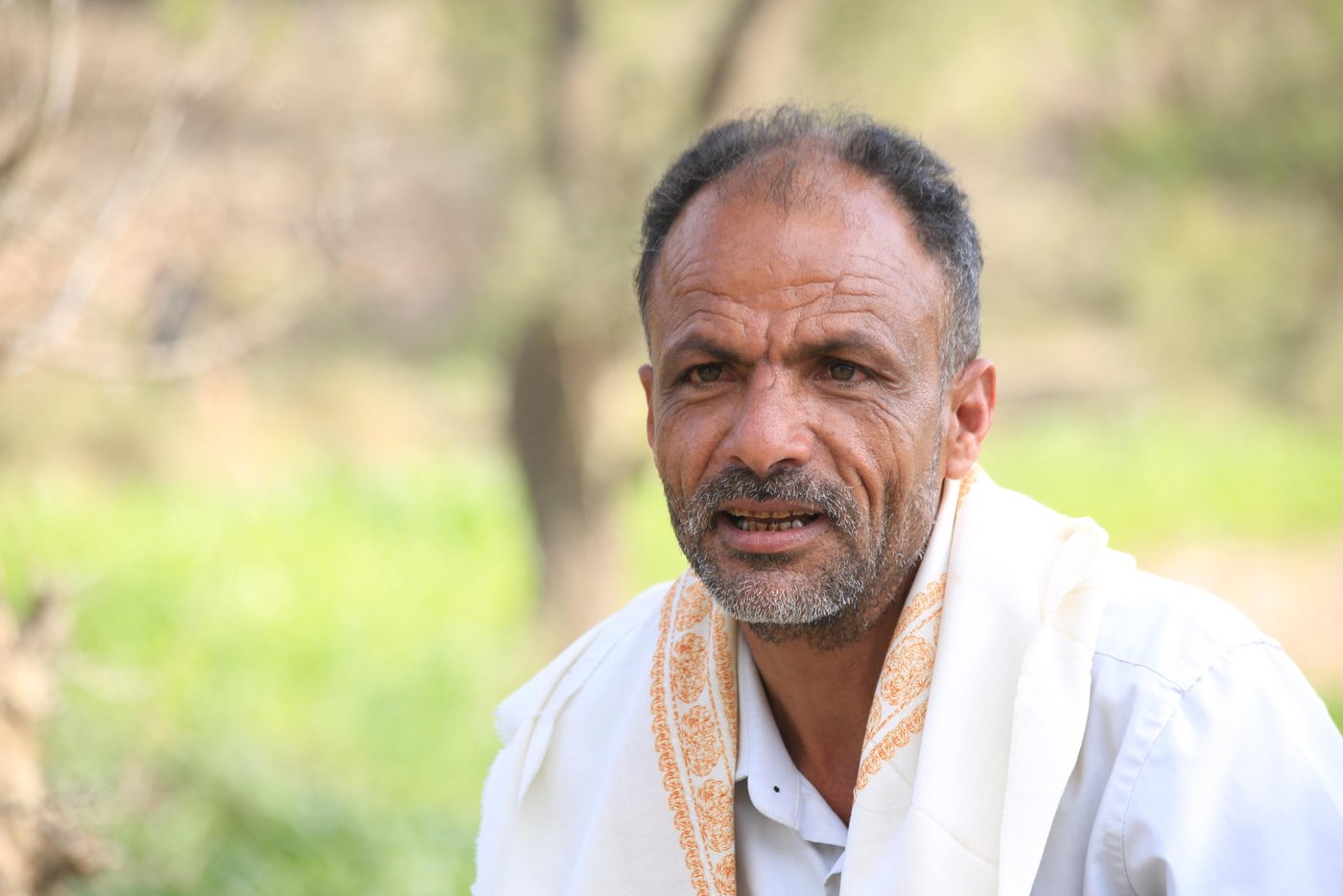 In Yemen, farming is no longer a profession only for those who inherited it from their parents. Because of the war, many people who have lost their jobs or don’t earn enough of a salary have now turned to the land.

Abdullah Qaid, aged 45, has spent 28 years as a teacher in Taiz’s Gabal Habashi district. His salary used to be enough to support his eight family members.

However, during the last five years the Yemeni currency collapsed from YER215 against the US dollar in 2015 to more than YER800 now. That has led to a huge increase in food prices, so many people can no longer afford it—including public workers like Abdullah.

“I’m a teacher and my salary doesn’t cover even the half of what my family needs. The situation of the people here in general is very bad. Before the war, some used to work in Aden, Sana’a or Al-Hodeidah to provide for their families.”

Teachers in Taiz governorate went without salaries for more than a year and only started receiving payments again in 2017 when food prices had already jumped.

“Since the beginning of the war, people have lost their jobs and they have returned to the village, where there is no chance of work. So a real tragedy was happening in this village.”

“A real tragedy was happening in this village… some families used to mix flour with animal feed and eat it”

Abdullah recalls an unforgettable moment for him, from a time now lost: “My home is near the main road and I used to see children’s smiles and happiness when they waited their fathers to arrive home from [jobs in] other governorates. Those smiles disappeared from the children’s faces after the war.”
 
Abdullah says that people were struggling to get food for their families. “Some families used to mix flour with animal feed and eat it, because they couldn’t afford the price of pure flour.”

People in Gabal Habsahi district used to plant corn in summer as feed for their cows, but they didn’t plant anything in winter and so the farms remained barren for six months a year.

They didn’t think about vegetable farming until the Norwegian Refugee Council (NRC) arrived in this little valley.
 
At first, there was resistance to the idea, because people didn’t know how it would work.
 
“When NRC arrived, we were told that they would provide us with support to start vegetable farming. The idea wasn’t clear and many people didn’t have any experience about vegetables farming,” Abdullah says.

“Then we received training from NRC and we learnt a lot. So we were happy to start a new experience of planting vegetables.”
With support from the Yemen Humanitarian Fund (YHF), NRC has now helped 500 famers like Abdullah in Gabal Habashi district with tomato, zucchini, okra, and onion seeds. The families were also provided with training, and cash to help them plough and water their farmlands.

Abdullah says that all the family members go to work in the fields, and they are happy to have a new source of income.
“Almost all the people in our village are farming now. There were some problems like the water source being far from some fields, but we overcame that problem by buying a pump.”

Another problem that farmers faced was the fees for ploughing fields, but that was solved by the cash they received from NRC.
“Now the valley is full of zucchini, okra and tomatoes. We have started to harvest zucchini and we will start selling tomatoes in ten days.”

Farmers sell twenty kilos of zucchini for YER3,000-4,000 and twenty kilos of okra for around YER5,000, which is a good price for customers.

“I can see the situation of families here is better now and my own situation has improved now with the beginning of the harvest season,” Abdullah says.

“Mothers harvest a basket and go to sell it in the market and buy what they need. Fathers do the same so families have money to buy what they need.”
 
Abdullah explains that the income from the vegetables isn’t enough to cover everything, but it helps to fill a big gap for these families.
 
Abdullah attributes the cheap prices at the moment to the harvest season, as all farmers are harvesting their crops at the same time so the markets are full of vegetables.

“There are many families who are benefiting from the low prices as they can buy cheap vegetables for their families.”
Abdullah considers this season as the best of the year, as all family members can earn money from selling the vegetables and can eat from their farmlands.

“The vegetable from my farm taste like honey to me. When I buy vegetables from the market, they don’t taste like the ones from my farm, which are so fresh. Sometimes I even cook them myself.”

“The vegetable from my farm taste like honey to me”
Abdullah believes that the high cost of seeds in Yemen is still the main problem threating this new wave of farming, especially because this is still the first year and so farmers are spending what they earn on basic goods.

“A packet of 1,000 zucchini seeds costs YER45,000. I as a farmer can’t buy it for this price, it is very difficult for me to save YER45,000 from what the vegetables earn this year.”

He confirmed that the farmers would be happy to continue farming if they get help with the seeds.

“Farmers now are in the middle of the journey, and they still need support. If they get more support next year they will keep going, as they are unemployed and don’t have any other work to do.”
Abdullah thanks NRC for this support. “NRC helped to re-light the good feeling in the hearts of farmers.”

Text: Nasser Abdulkareem/NRC
Photo: Khalid Al-Banna/NRC