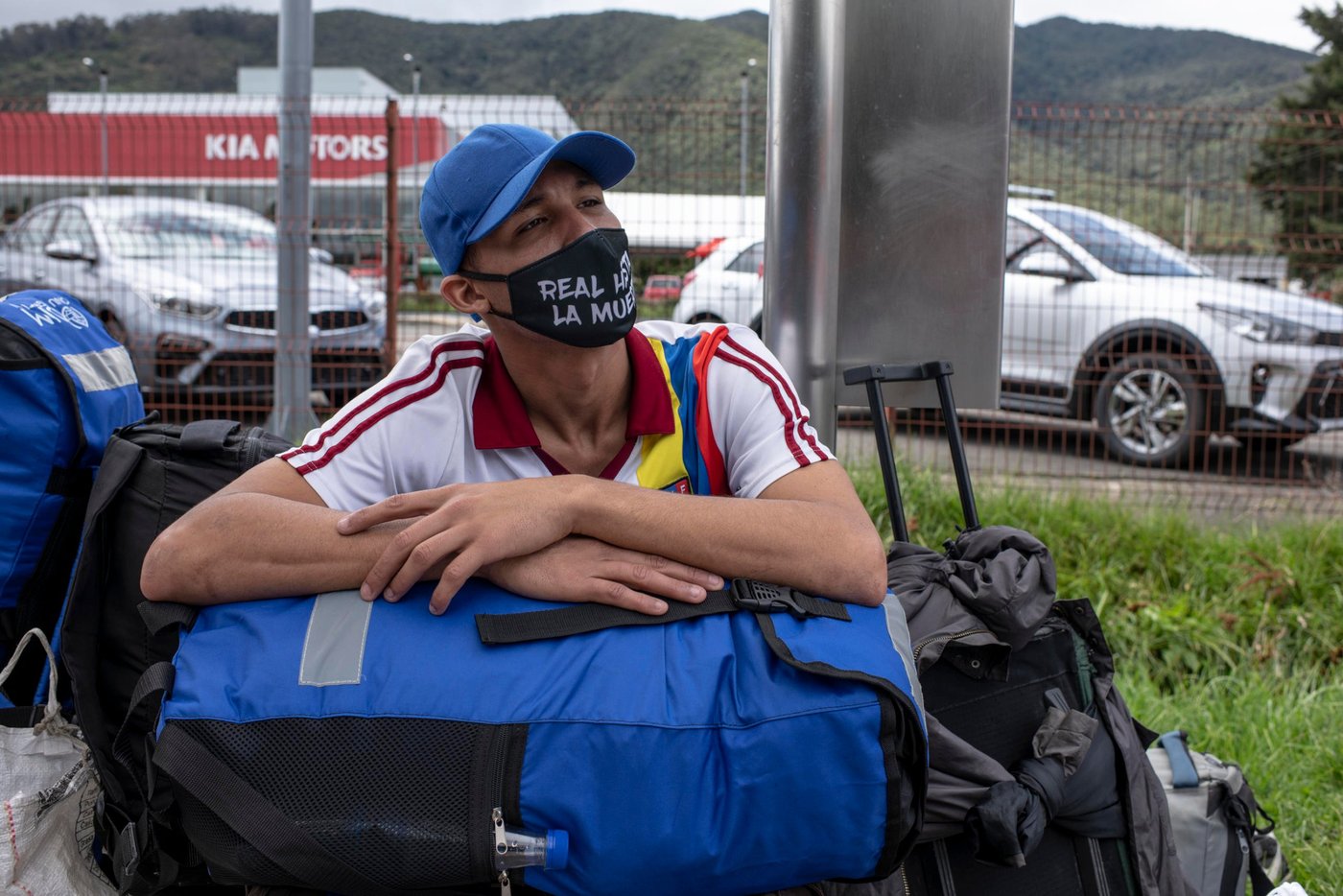 June 19, 2020. Colombia: Hector Castillo (23) is a Venezuelan migrant native from Caracas. He just received a bag and stuff from the NGO NRC to give him better walking conditions. He is in Colombia since one and a half years. He's been walking all day with two other friends. They hope to reach the city of Paipa, some 200 km from Bogota, where the aunt of one of his friends will give them shelter for a while. Today he says, in relation to the crisis: "The only thing we can do is walk.".  Credit: Nadège Mazars for NRC