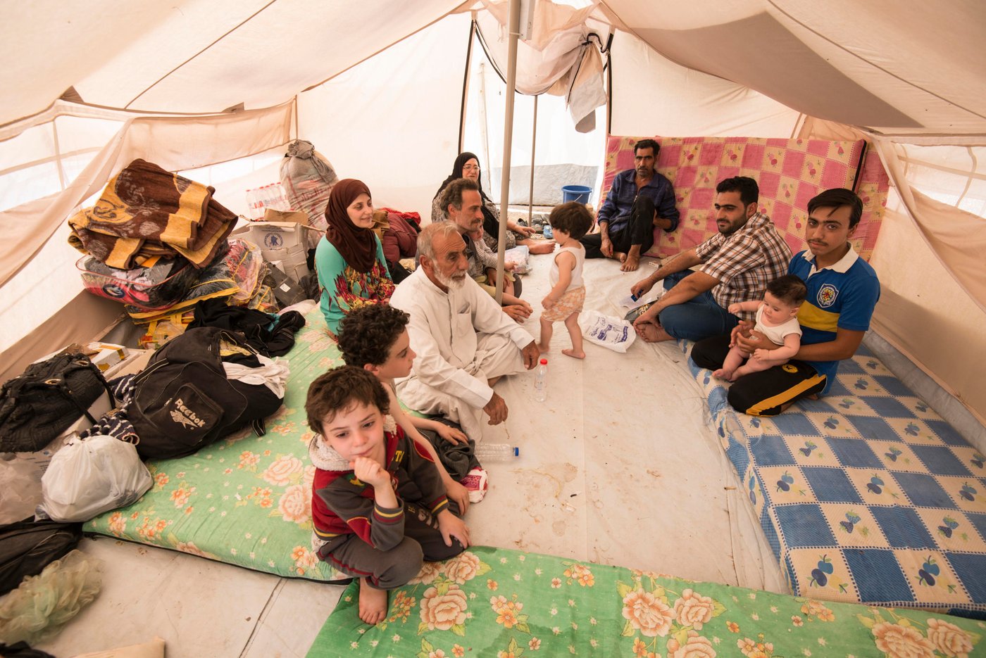 Nafa Yacob (in white) fled ISIS territory in Anbar province, Iraq, to save his 14 year old grandson (in blue) from being forcefullly recruited by ISIS. Over 10,000 have arrived to displacement camps close to Ramadi, Anbar province, since the beginning of October according to the Norwegian Refugee Council (NRC), who provides emergency aid to these people.
Melany Markham/NRC October 2017