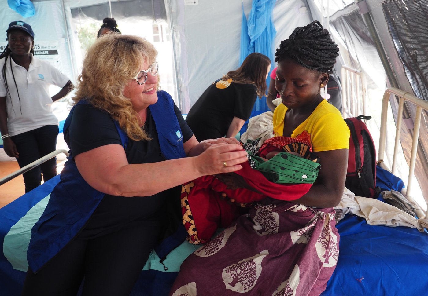 NORCAP Executive Director, Benedicte Giæver, takes a look at Mariamo's (29) newborn baby, just a few hours old. Mariamo is now a mother of five. 

Giæver visited the cyclone Idai-affected areas of Mozambique in June 2019 to see the work NORCAP experts are doing, meet with partner organisations and get more information on how NORCAP can support future operations. 
(Photo: NORCAP/Ida Sem Fossvik)
