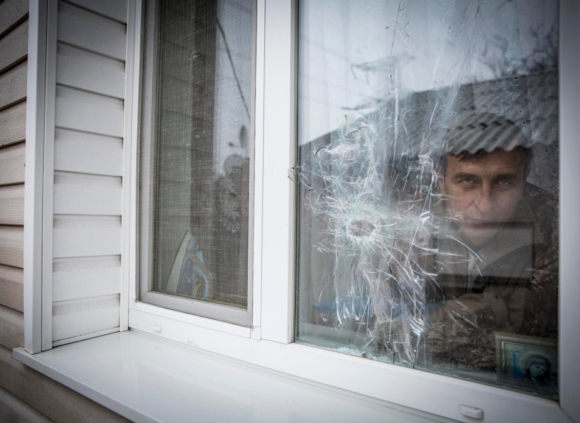 “I missed my home”. Yurii Polieshko returned to his village by the contact line after some time in Russia despite damages to his house, loss of income and frequent shelling. 

Liudmyla, 51 and Yurii Poleshko, 55, lives in the frontline village Zaitseve in Donetsk region. For the last three years they have been unable to find jobs and survive only owing to humanitarian assistance and relatives’ support. 

“We used to have levelled life. We did our own business. My wife owned a hairdressing salon, I was the owner of ventilation system control enterprise in nearby Horlivka (currently non-government controlled area). We were providing our services in several regions – from Luhansk to Zaporizhzhia in eastern Ukraine. However, the conflict, which came to our country in 2014, turned our life upside down. Initially, when the hostilities started, we tried to continue our work, but when the crossing point was set up in our village, we were urged to shut down all our business, because of limited access to that area. It was in August 2014. ”, - says Yurii Poleshko. 

Since the conflict outbreak, Zaitseve has become one of the hot spots of crossfire between conflicting parties. One part of the village is under Ukrainian Government control, another under de-facto authorities.  Despite the ceasefire agreement, the hostilities are still ongoing., Usually the shelling starts there, when it gets dark, sometimes the incidents happen in the daytime. At the streets you can hardly find its residents, people try not to come out unless it is absolutely necessary. Most of the windows in the houses are closed with plywood, firewood and shields. People use all possible means to protect themselves. Many residents left the settlement, mostly the elderly people remained. 

 “We felt abandoned. For a while it was no man’s land. In 2014 it was even difficult to bury someone in the settlement, because administratively the settlement was subordinating to non-government-controlled Horlivka”, recalls Yurii. 

“Initially we left the settlement in December 2014 after very heavy shelling, the whole night we were sitting in the basement. It was too stressful for us. For 8 months we were staying with relatives and friends.  Our friend even proposed to buy a house for us in Russia, but we refused, because there is nothing like home”, - says Yurii. 
“We cannot explain why we returned. We are probably too attached to the house. How could we leave all this? Yes, it is scary to hide in the basement. But when you come out from it you are home”, says Liudmyla. 

In 2016 Poleshko’s house was damaged by shrapnels. They could enter the house only through the window, because the door was curved by the explosion and could not open. The family repaired the house. However, when you enter the house, you can still see the shelling traces; holes in the windows, ceilings and walls.  
“I have nine years to wait before I can receive my pension. For three years we haven’t had any income. Now we are fully dependent on humanitarian assistance and our relatives”, - says Liudmyla. 

Recently, the Poleshko family started receiving cash for foodstuff from NRC. Thus, the family will be secure with food for five months during the cold season. 

“It is better to receive cash than to get in-kind assistance, because sometimes what you need is to buy the gas bottle before you can cook the food. Some people are on diet due to health issues, so they can buy food according to their own needs. For us such assistance is crucial. We are not pensioners yet. But we are vulnerable, because we cannot find the way to earn money. Psychologically it is difficult to depend on humanitarian assistance, as we used to be self-sufficient in the past”, - says Yurii.

Photo: Ingebjørg Kårstad/Norwegian Refugee Council
