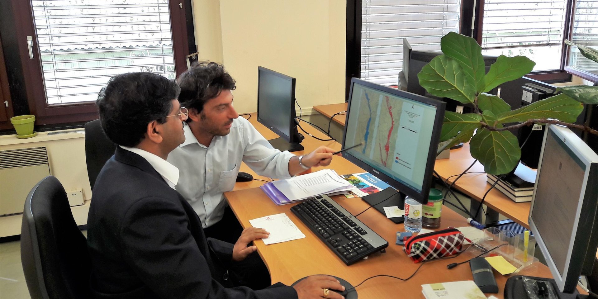 NORCAP expert Hari Prasad Vajja (left) with a UNOSAT colleague looking at flood maps connected to the UNOSAT Flood finder tool. (Photo: UNOSAT)
