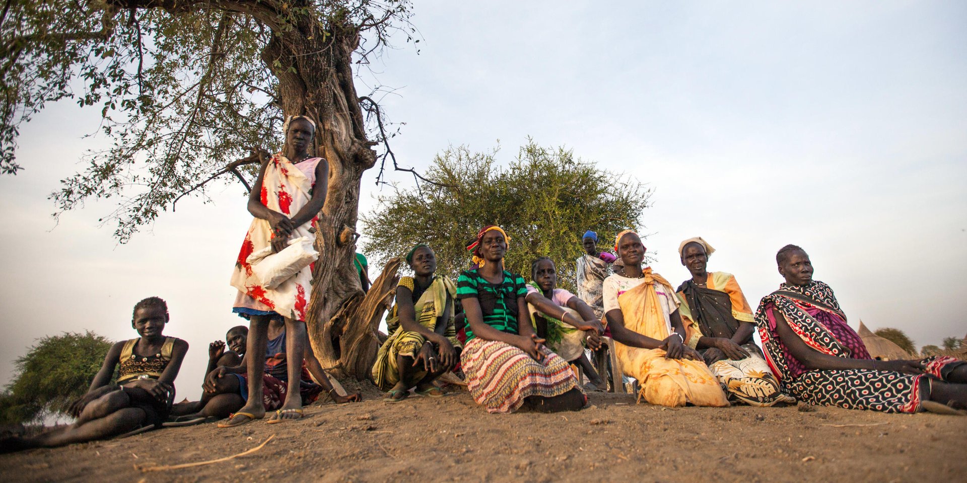 7 March 2017, local women sit under the tree waiting for food distribution in Ngop, Unity State, South Sudan. Photo: Albert Gonzalez Farran/NRC