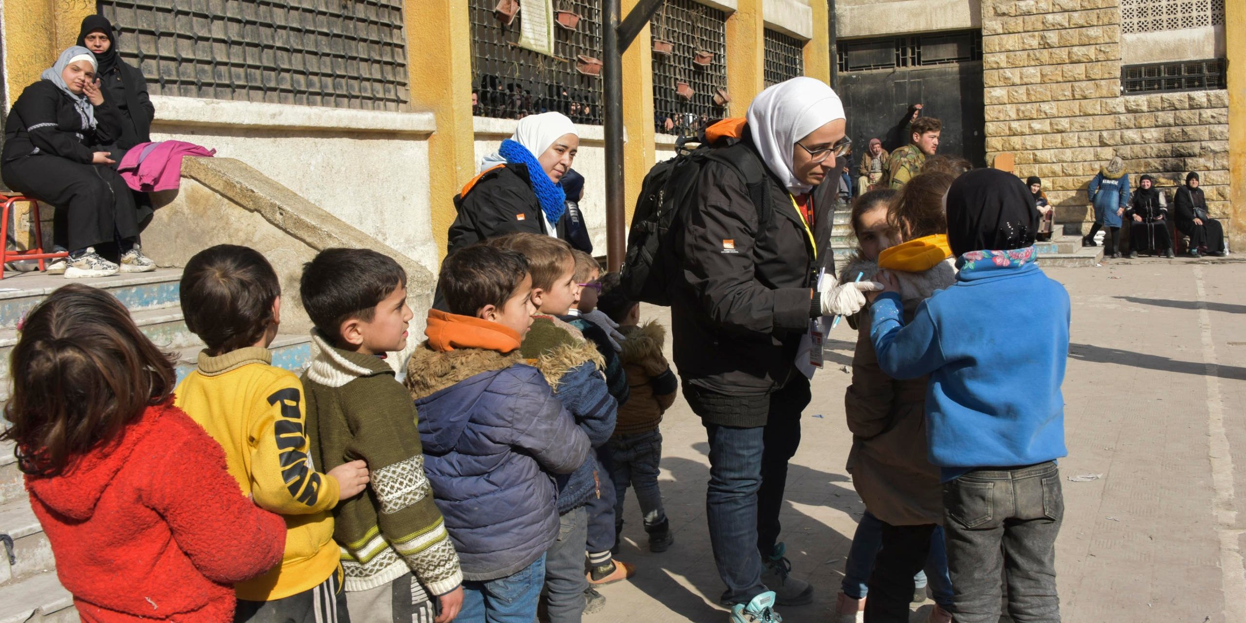 NRC staff helping children.