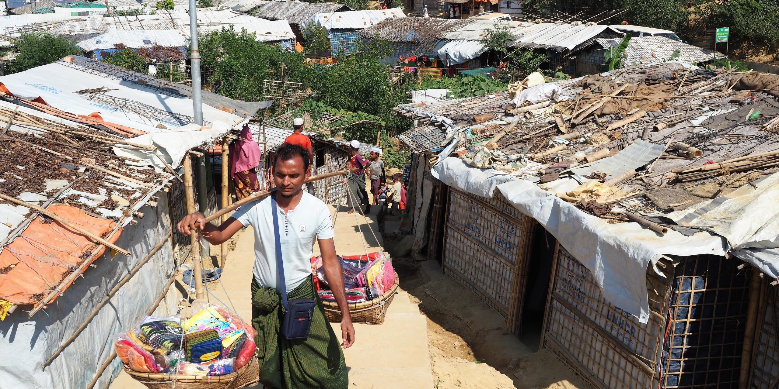 A local vendor, selling small items, walking through the Kutupalong refugee camp in Bangladesh. The Rohingya are not allowed regular jobs in Bangladesh, so they have to find other ways to support themselves. (Photo: NORCAP/Ida Sem Fossvik)