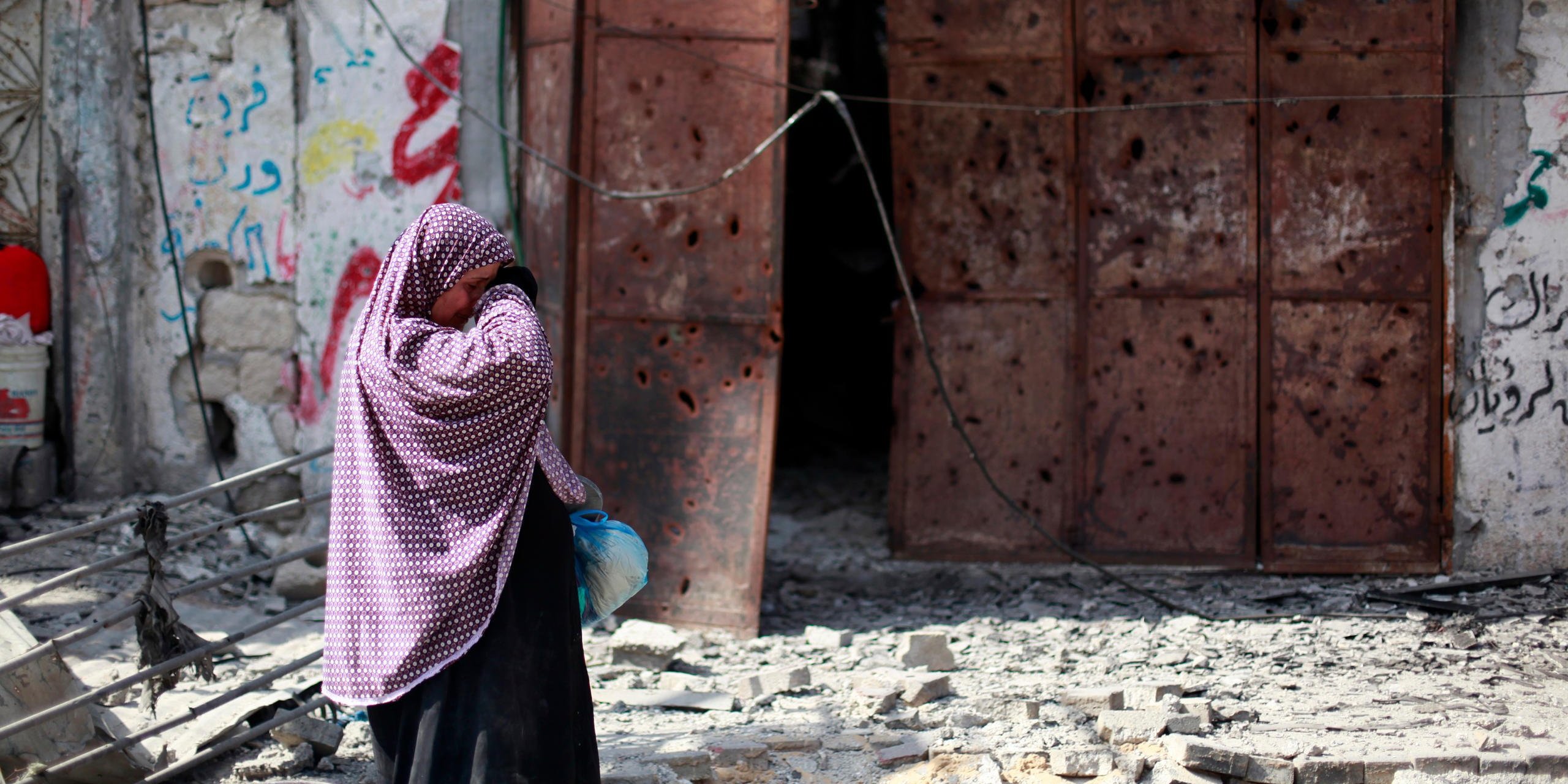 Woman crying upon seeing her destroyed house during the ceasefire, Al Shajaeyah, 26 July 2014. Photo Credit: Emad Badwan