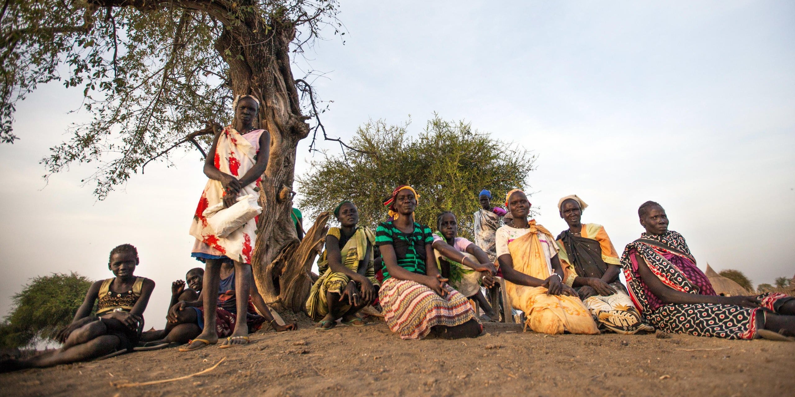 7 March 2017, local women sit under the tree waiting for food distribution in Ngop, Unity State, South Sudan. Photo: Albert Gonzalez Farran/NRC