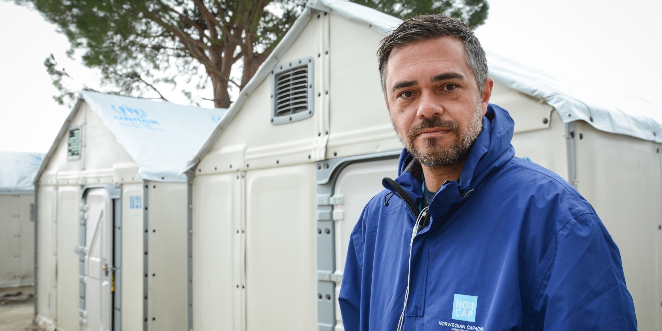 NORCAP-expert Patric Mansour standing in front of temporary shelters in the Moria refugee camp on Lesvos. (Photo: NRC/Tiril Skarstein)