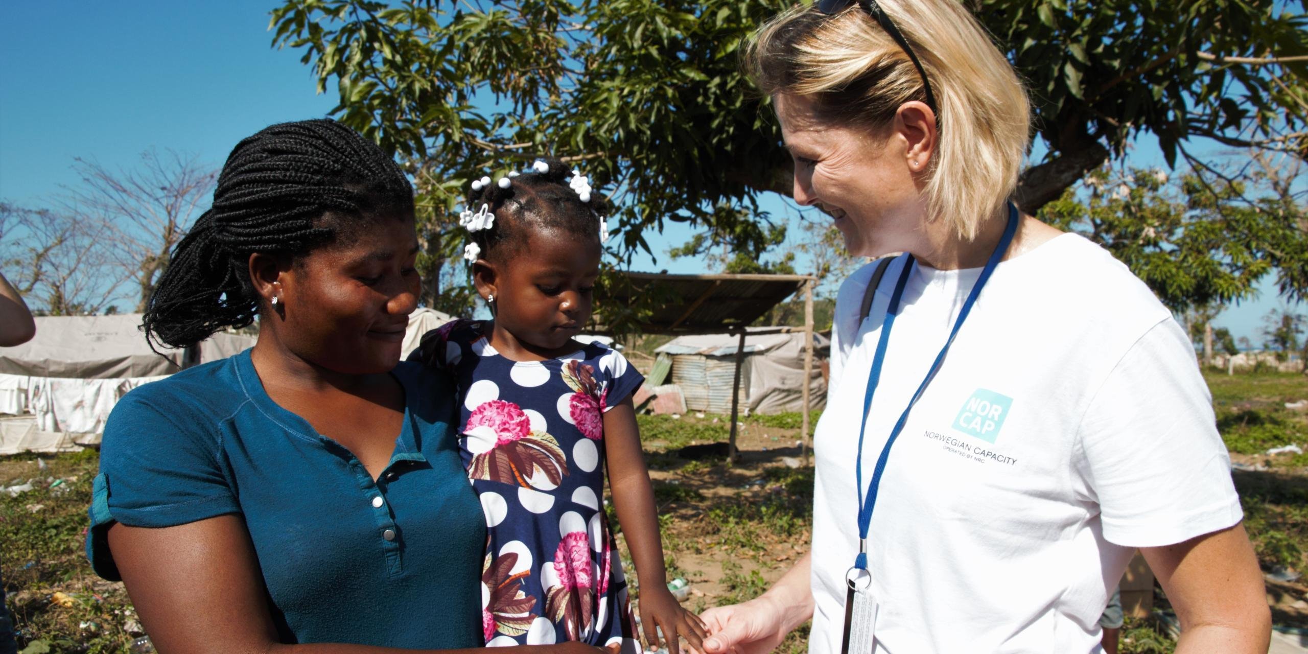 Protection expert Helene Ruud, deployed to WFP in Haiti after hurricane Matthew in October 2016, talking to an affected family in Jeremie, Grand Anse province. (Photo: Ingrid Prestetun/NRC) 