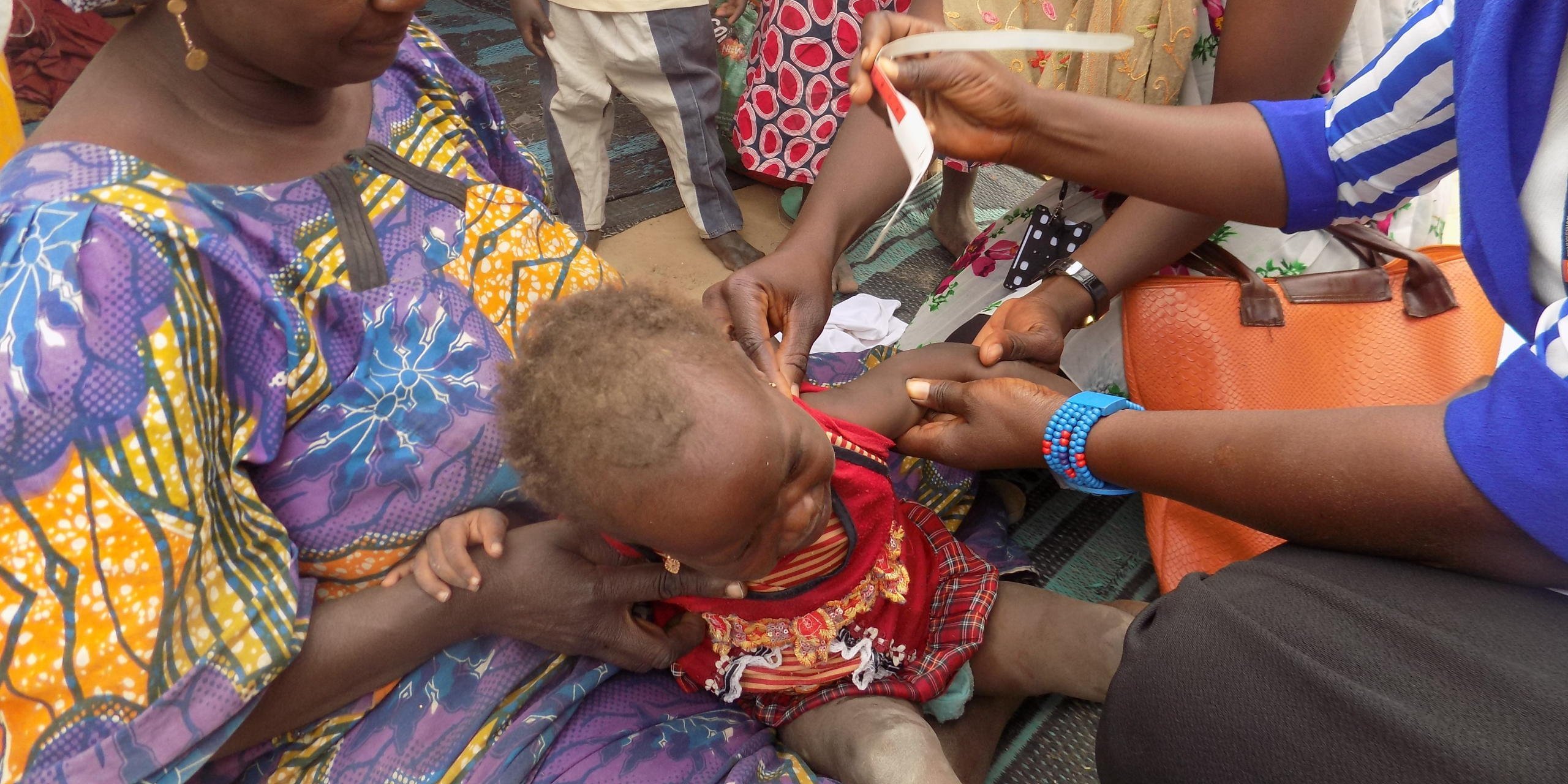 NRC hygiene promoters conduct MUAC screening on a child (NRC Nigeria/Rosalyn Velds)
