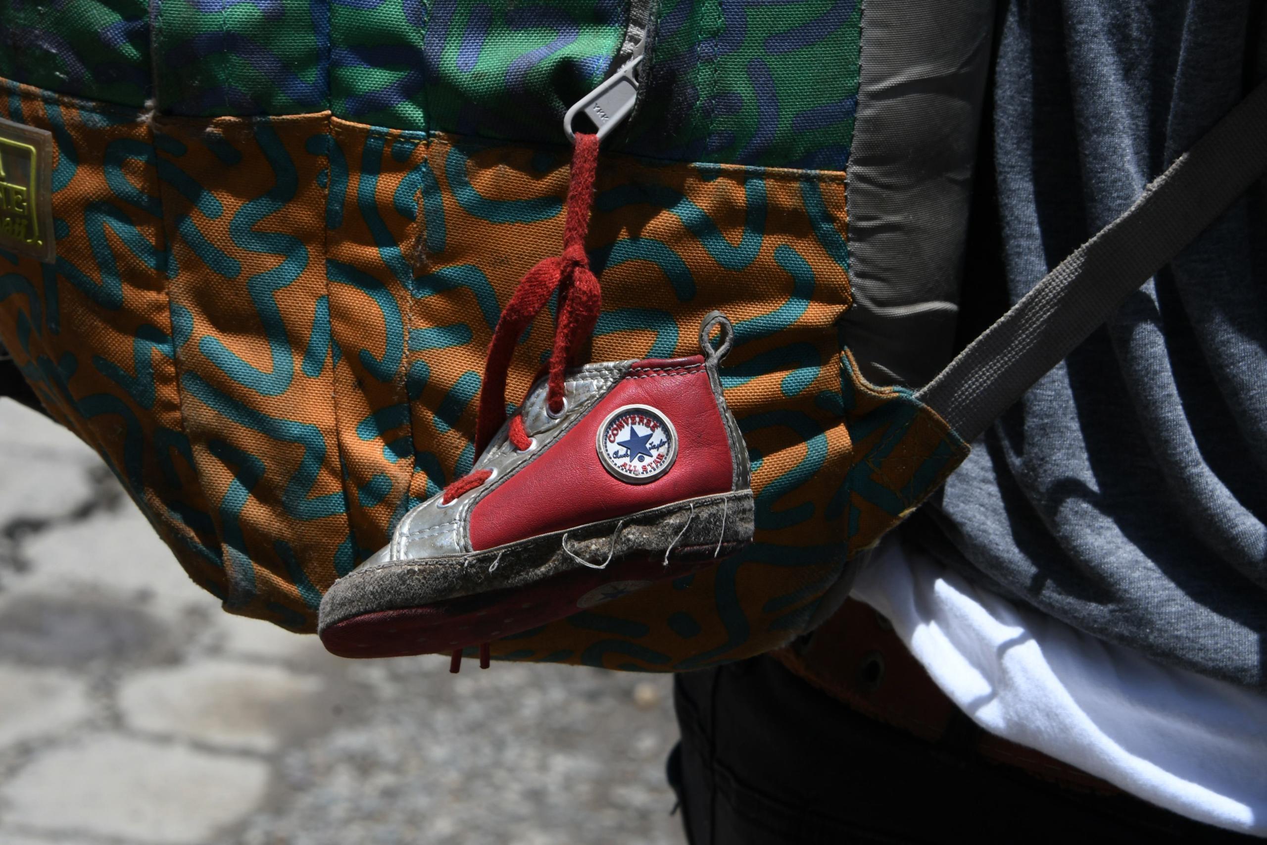 A little shoe that belongs to his baby girl hangs from the backpack of Honduran immigrant Ever Sierra, 28, who was deported from the US and arrived in San Pedro Sula, 200 kilometres north of Tegucigalpa on June 22, 2018.
Ever, was separated form his wife, Iris Yaneth, 26, and their eight-month daughter to be locked up in a detention center in McAllen, Texas, US and then in Lousiana before being deported. Notwithstanding the struggle, Ever is determined to resume in the next few hours his return to the US, where he hopes to reunite with his family. / AFP PHOTO / ORLANDO SIERRA