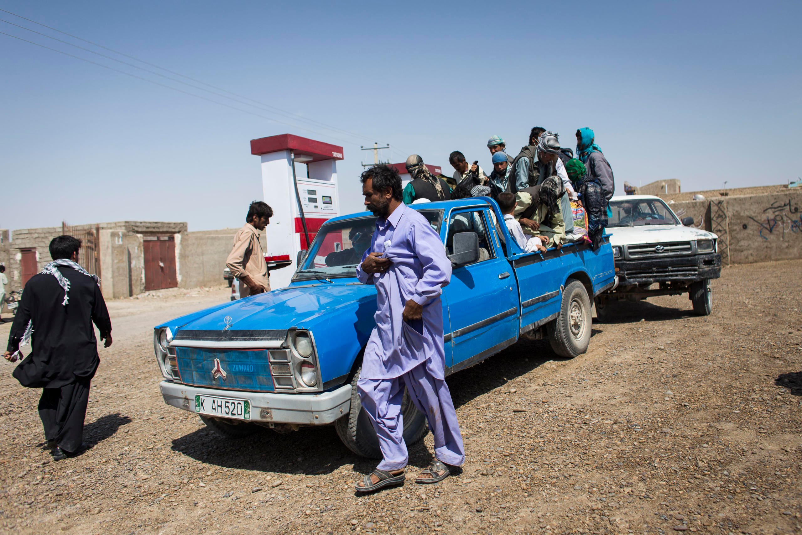 Ranging in age from 13 to 55, a group of Afghan refugees mount a pick-up truck at a petrol station on the outskirts of Zaranj. The treacherous trip they are about to undertake will take them through the Baluchi desert from Afghanistan through southern Pakistan across the border into Iran. Photo: NRC/ Jim Huylebroek