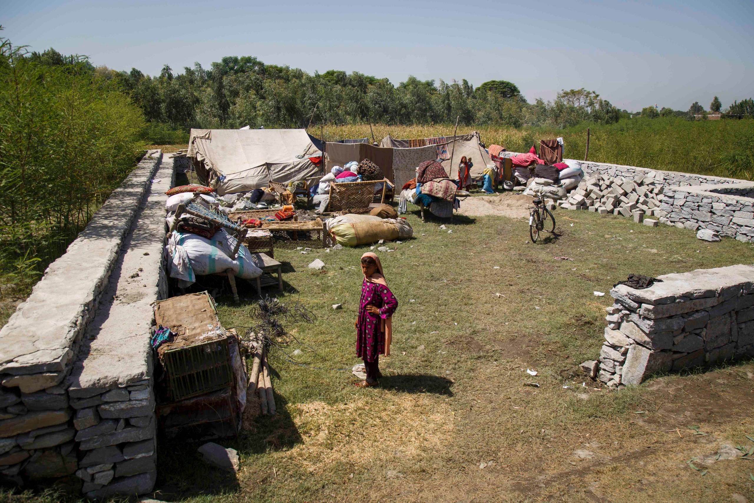 A girl stands in front of her family’s tents—her new home after her father and uncle felt forced to leave Pakistan four days ago.  There is no water or bathroom here, and they only have food enough for a few days. (Photo: NRC/Jim Huylebroek)
