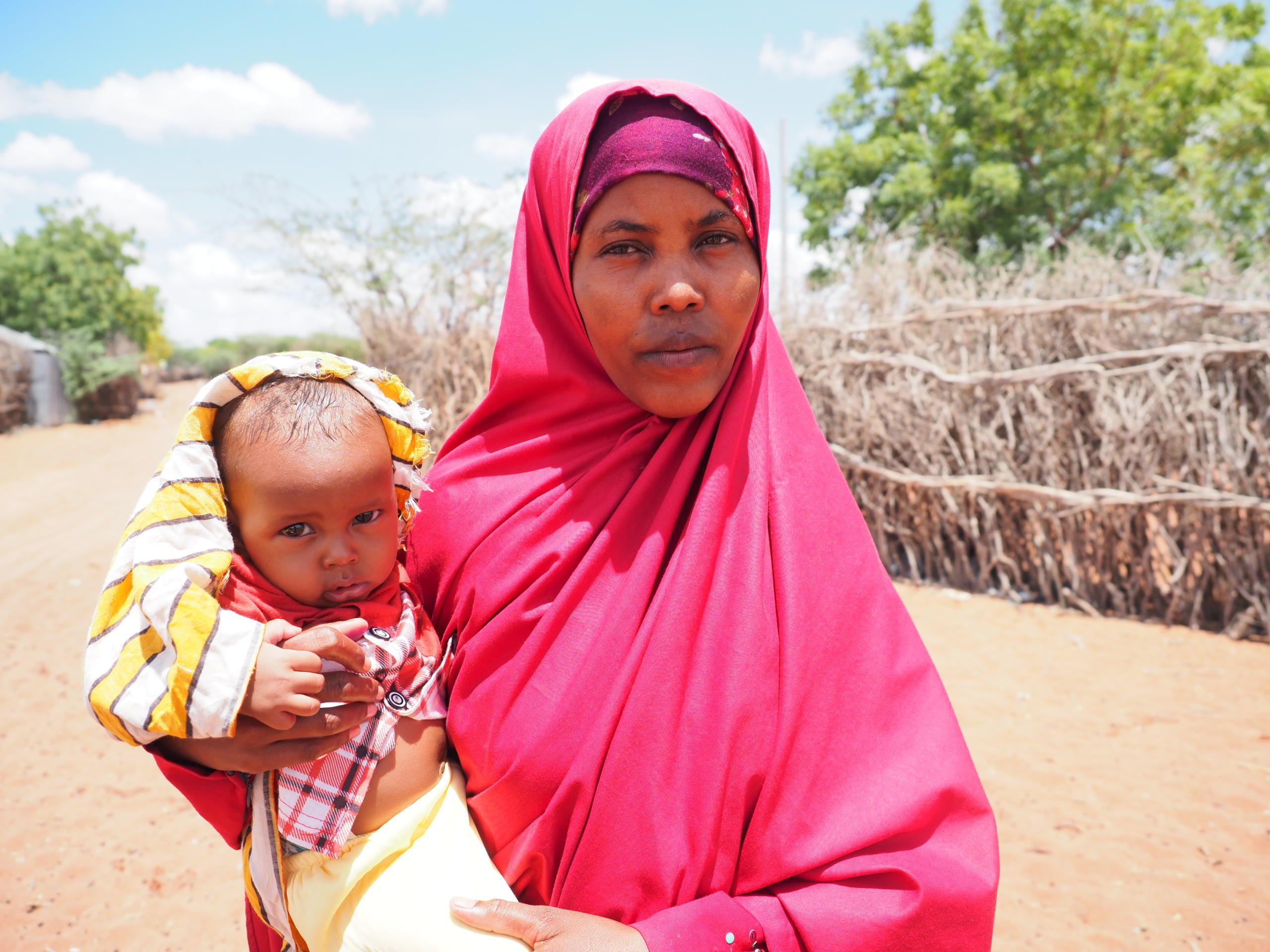 Halima Ahmed (24) and her 18-month-old son Mascud outside their home in Hagadera camp, Dadaab Refugee Complex, Kenya. Halima is planning to repatriate to Somalia with her four children and join her husband, who has already moved back to their country of origin after almost 10 years living as refugees.