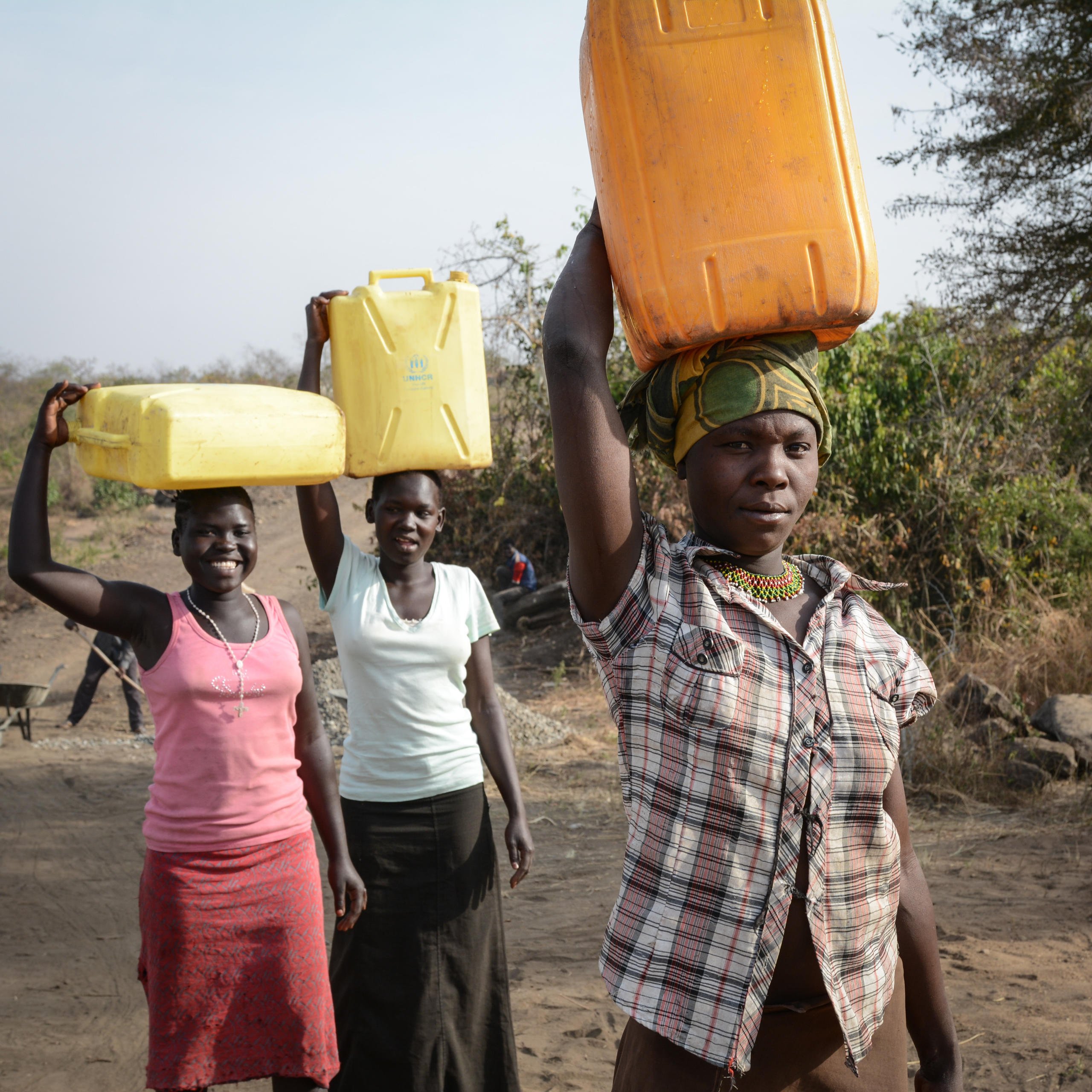 Never Rukia (28) from Uganda in front and Mary Kiden (17) and Christin Awate (16) from South Sudan are collecting water from the same water point in Bidibidi. NRC has constructed the water point, which is being used by both refugees and the host community.
Bidibidi settlement in northern Uganda was established in August 2016 and has quickly become one of the world's largest refugee settlements. By January 2017 it was housing more than 270,000 refugees from South Sudan - and had reached its full capacity. NRC is providing water and sanitation services in the settlement.
In total, Uganda is currently home to about 600,000 refugees from South Sudan.
Photo: NRC/Tiril Skarstein
Quotes from Mary Kiden:
"People are being killed in South Sudan. Equatorians and Dinkas are fighting each other.
I feel free now. Here we no longer need to listen to the sound of the guns. Some times we heard the sound of guns the whole night. People were killed. It made me afraid.
Because of the conflict, prices also went up at the market.
It is fine to be in Uganda. We feel very welcome here. They allocated us a piece of land, we have free access to hospitals and we feel safe.
The Ugandans in the area benefit as well from many of the new services. I think that’s good."
Quotes Never Rukia:
"Wars are no good for the civilians. I have understood that, when speaking with the refugees coming here. I am glad Uganda can give them land and provide security.
It feels good to have these people in the neighbourhood.
It has some benefits for us as well. There are for example more goods being sold at the market now. And there are clean water sources available to us, as well as the refugees.
I think we should stay together in harmony and share the available resources."