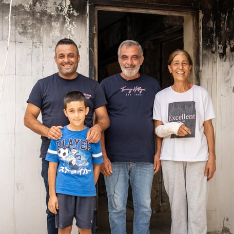 Familj som står utanför sitt hem.