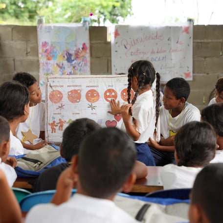 Lärare undervisar i ett klassrum framför en whiteboard.