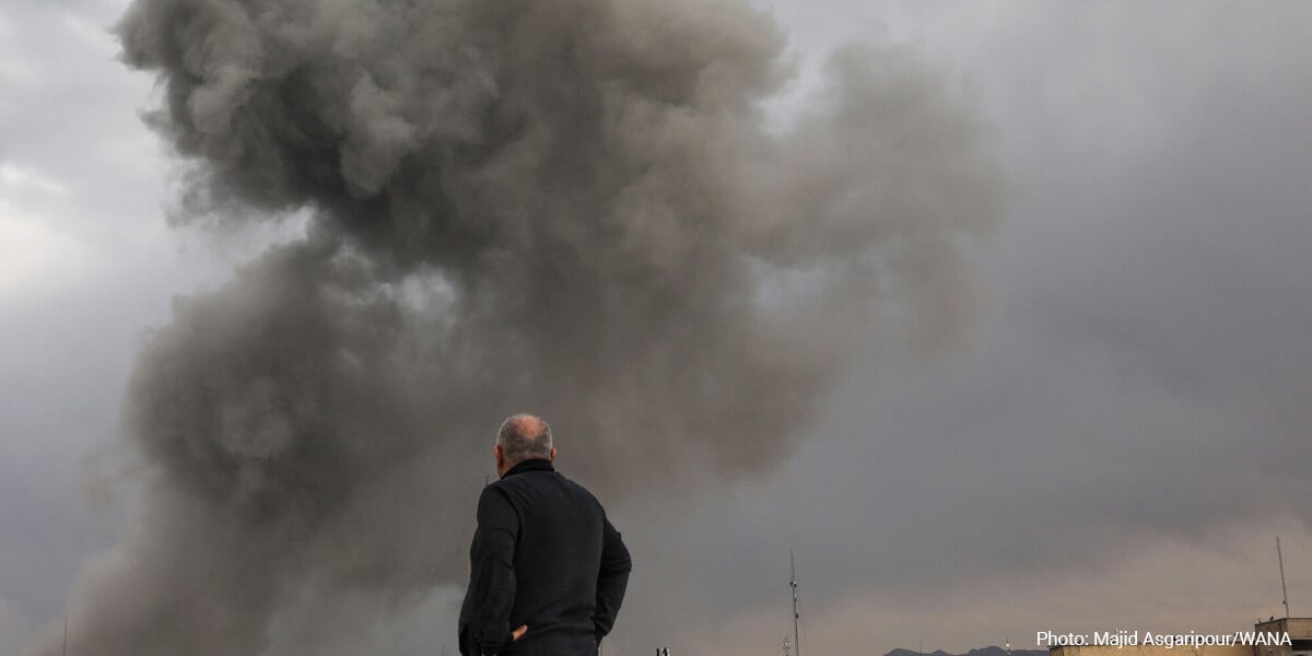 A person watches the smoke rising after an explosion.