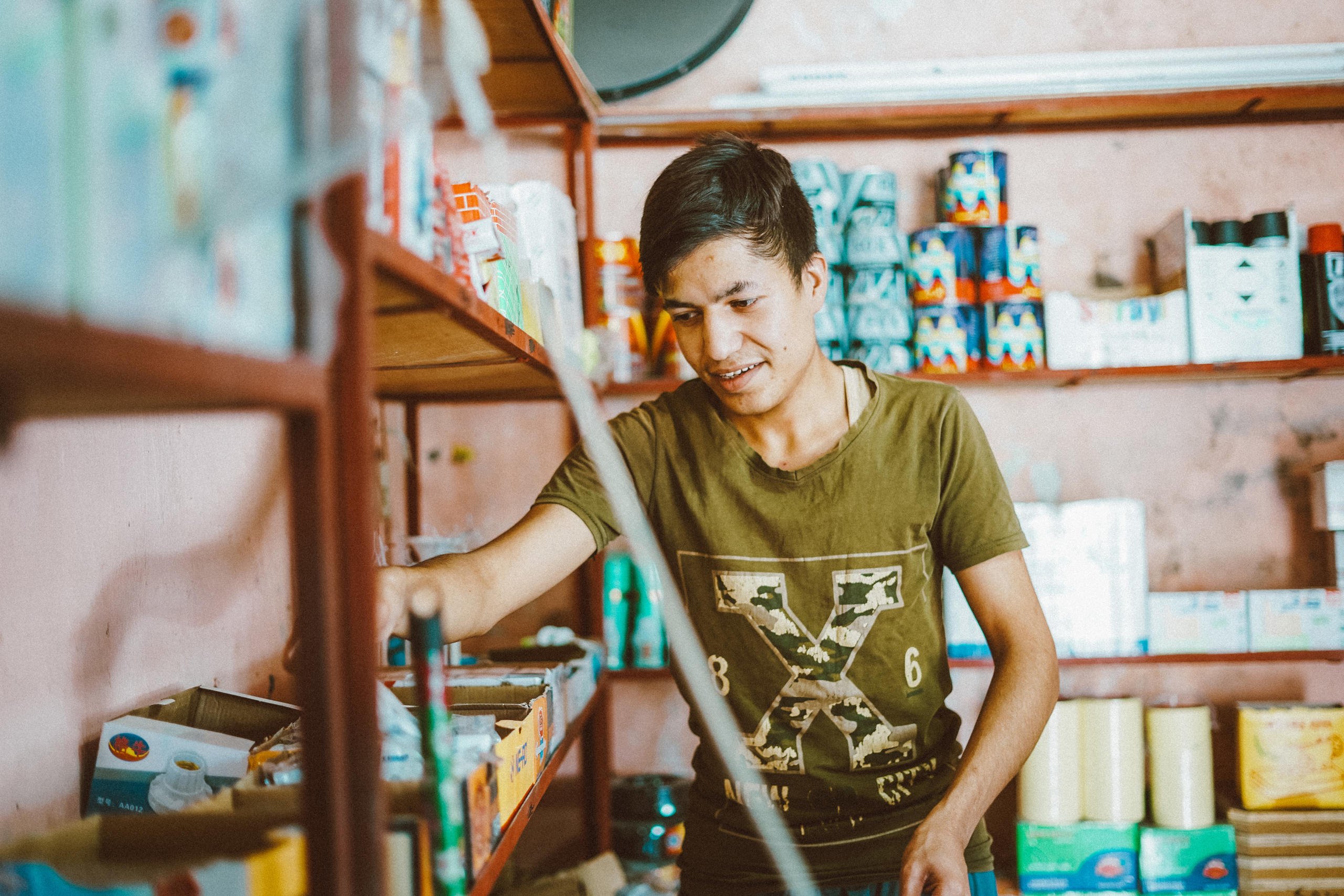 Ahmed* inside his shop. Ahmed lives in Hamam Alil district in Ninewa government. After ISIS defeat Ahmed is resuming his education and at the same time, he is managing a shop for hardware tools to provide income to his family. Photo: Zaid Al-Bayati/Oxfam