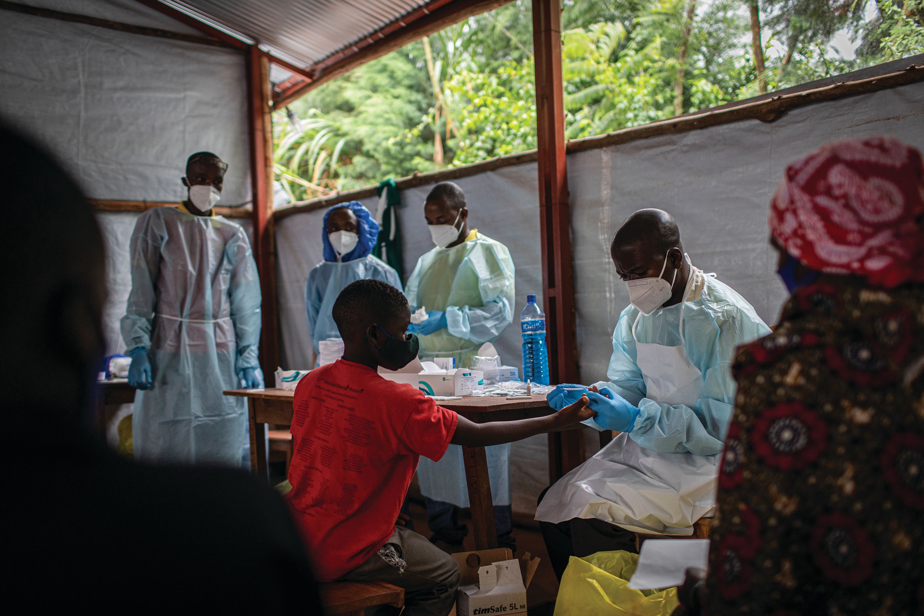 A boy receiving a vaccine shot from medical staff.