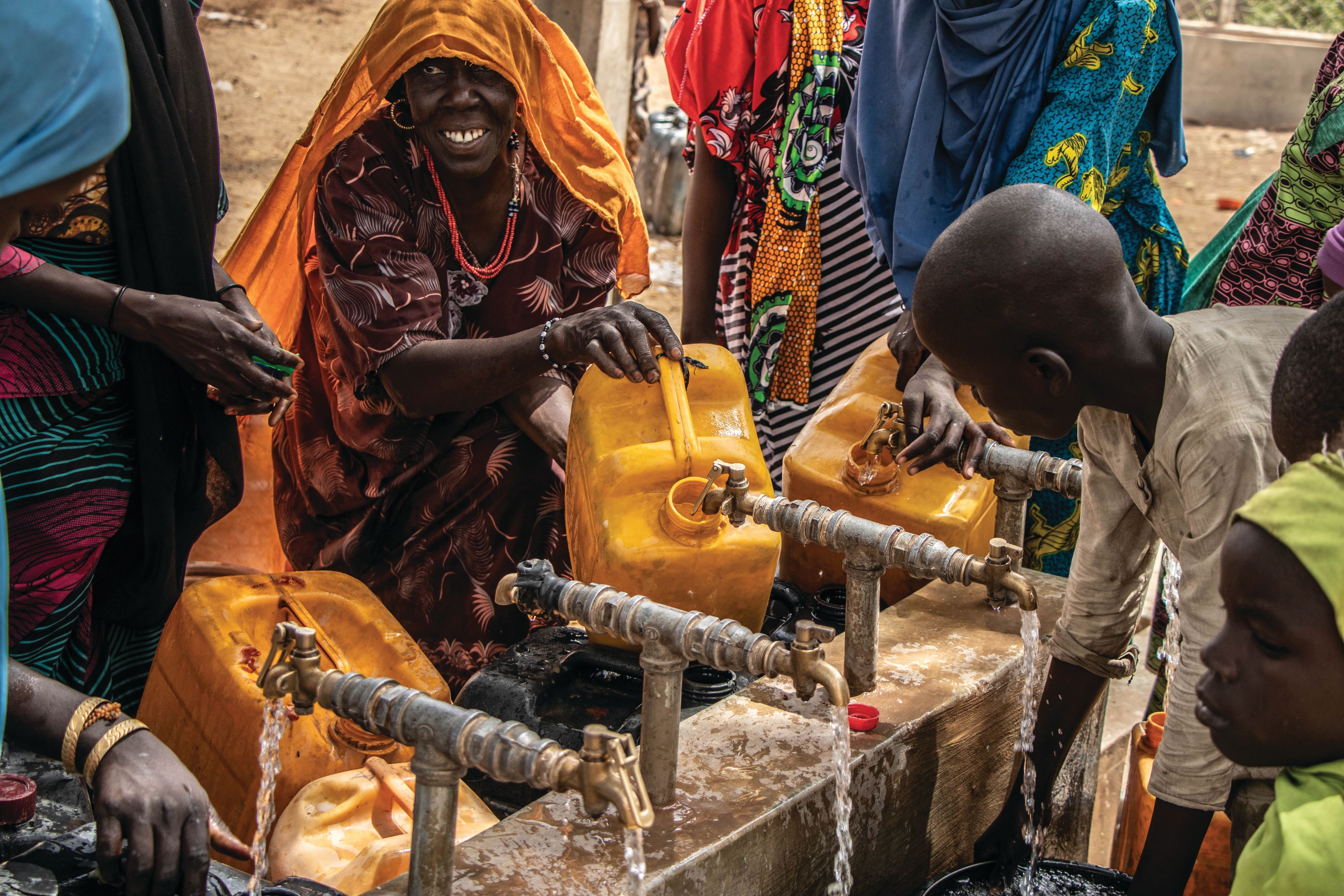 Women and children gather at a water point.