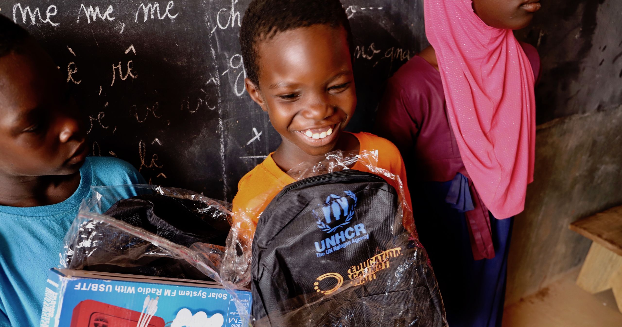 Malian internally displaced children receiving school kits and solar powered radios to ensure learning during school closures due to Covid-19 measures.