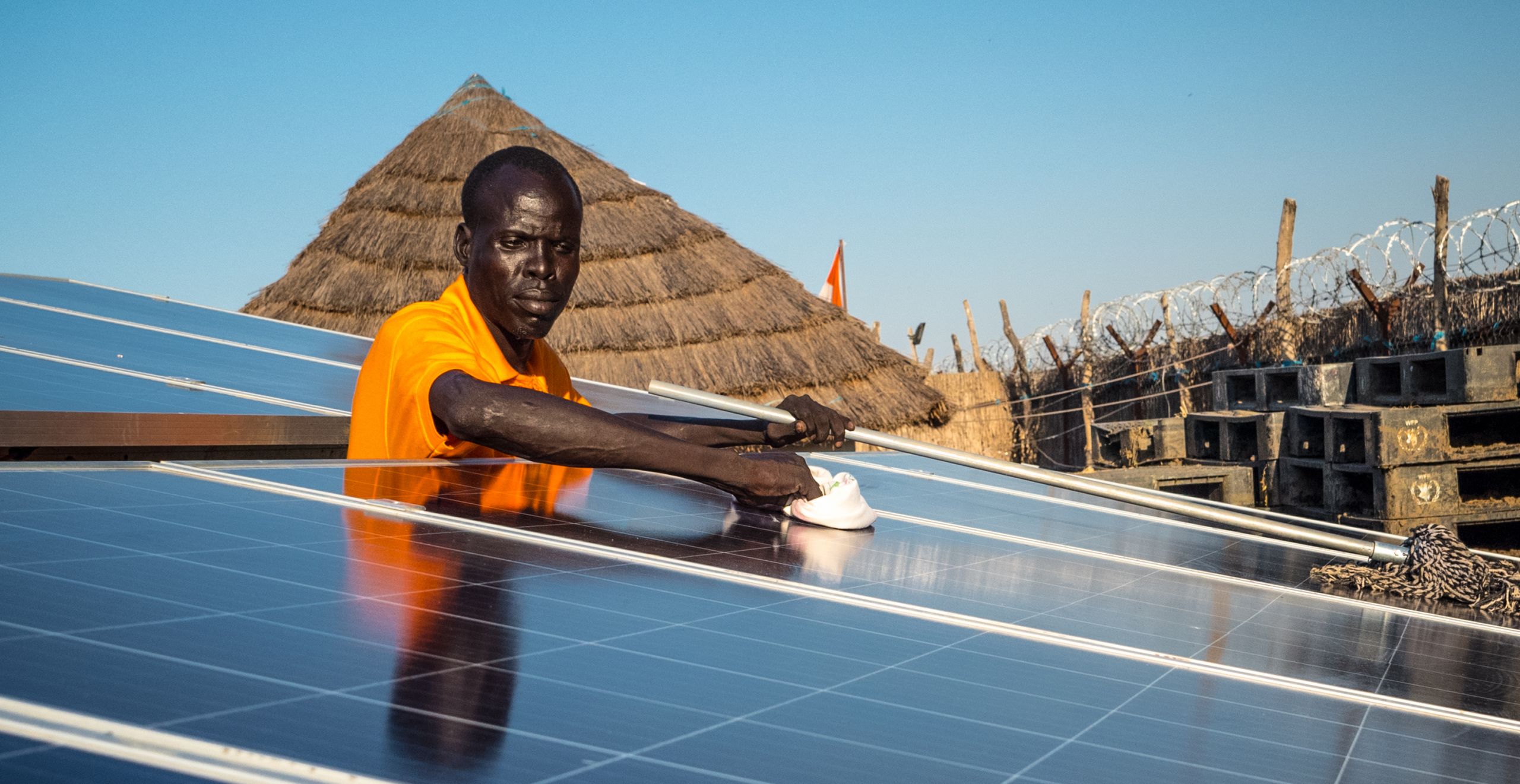 New solar panels being cleaned for optimal results by local volunteer Michael Gatluak, at the Norwegian Refugee Council's office in Mankien, South Sudan.