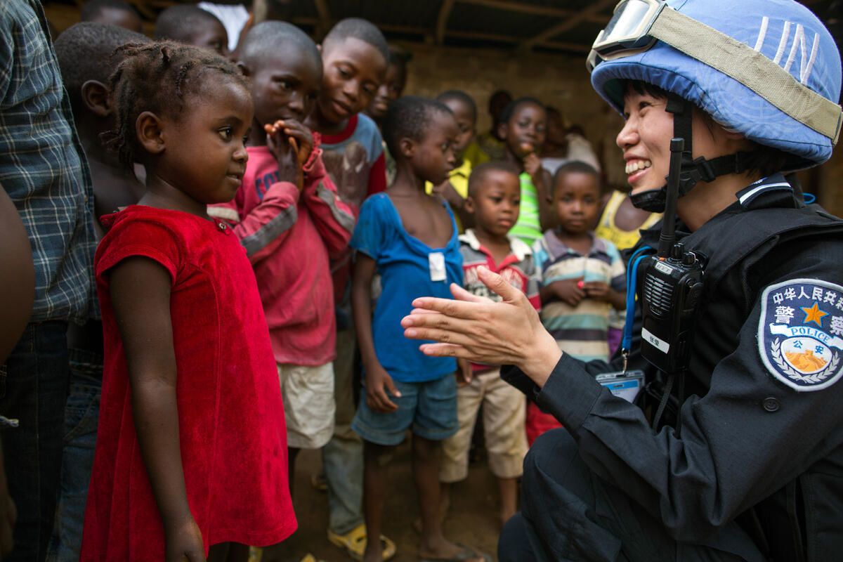 Zhang Ying, a member of the Chinese Formed Police Unit deployed with The United Nations Mission in Liberia, interacts with a girl of the Steward Camp in Tubmanburg