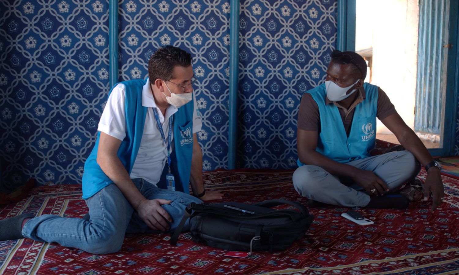 Gabriel handing over his work to Ismali, a national UNHCR education professional.