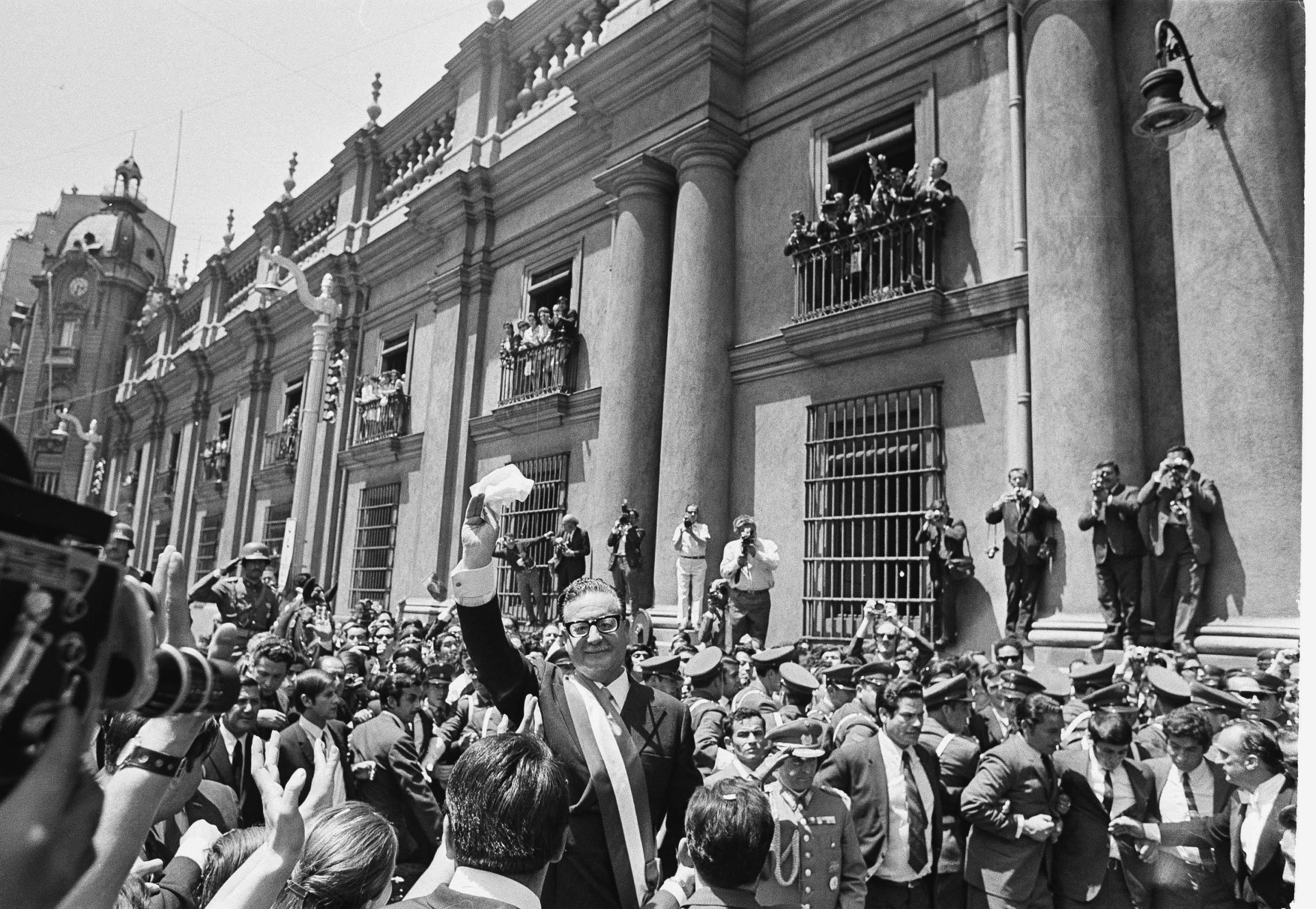 Newly inaugurated president of Chile, Salvador Allende, waves as he walks through the streets from Congress to the cathedral in Santiago, 3 November 1970.