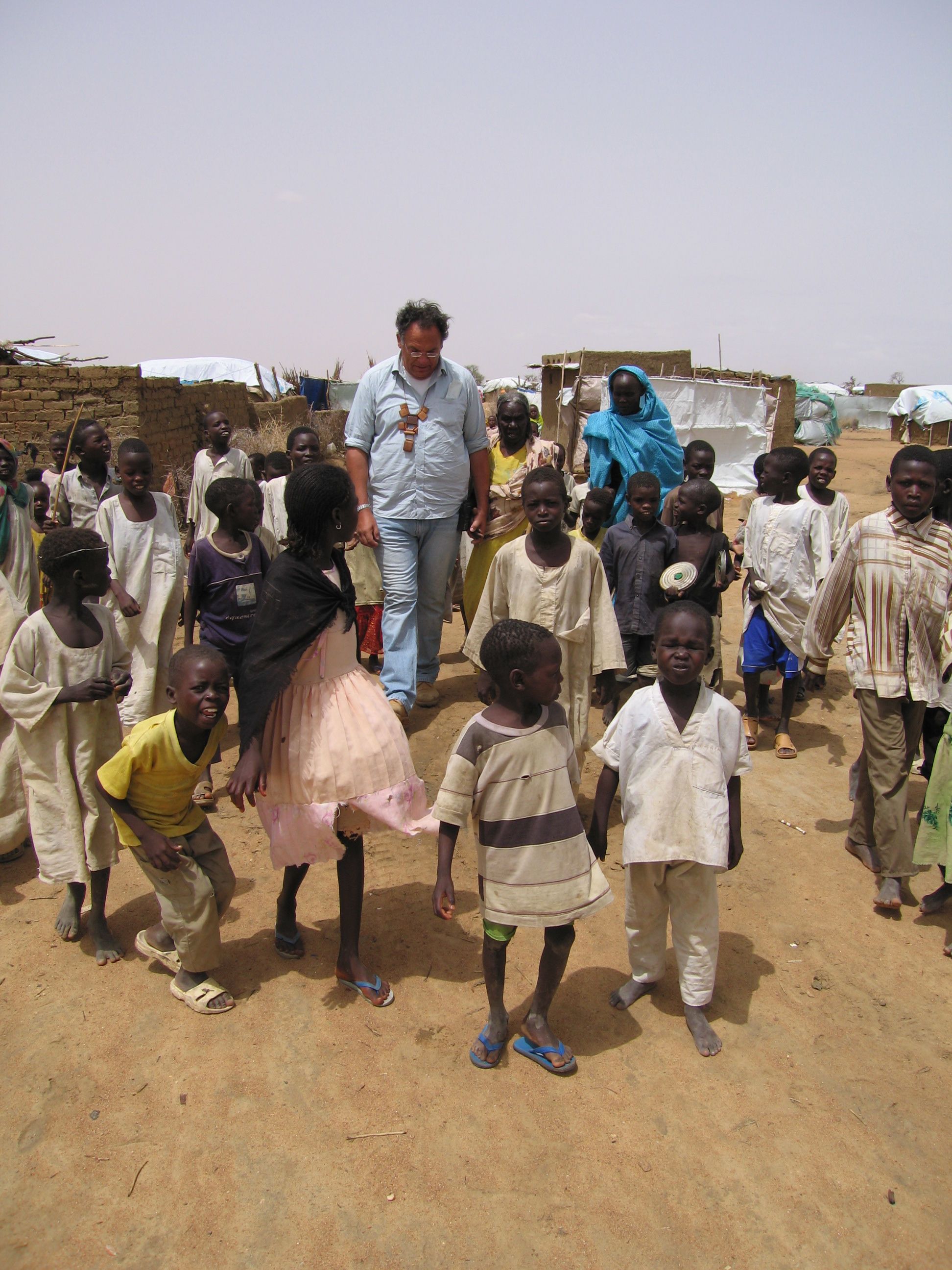 Alfredo standing among a group of children in Kalma displacement camp, Darfur, 2006.