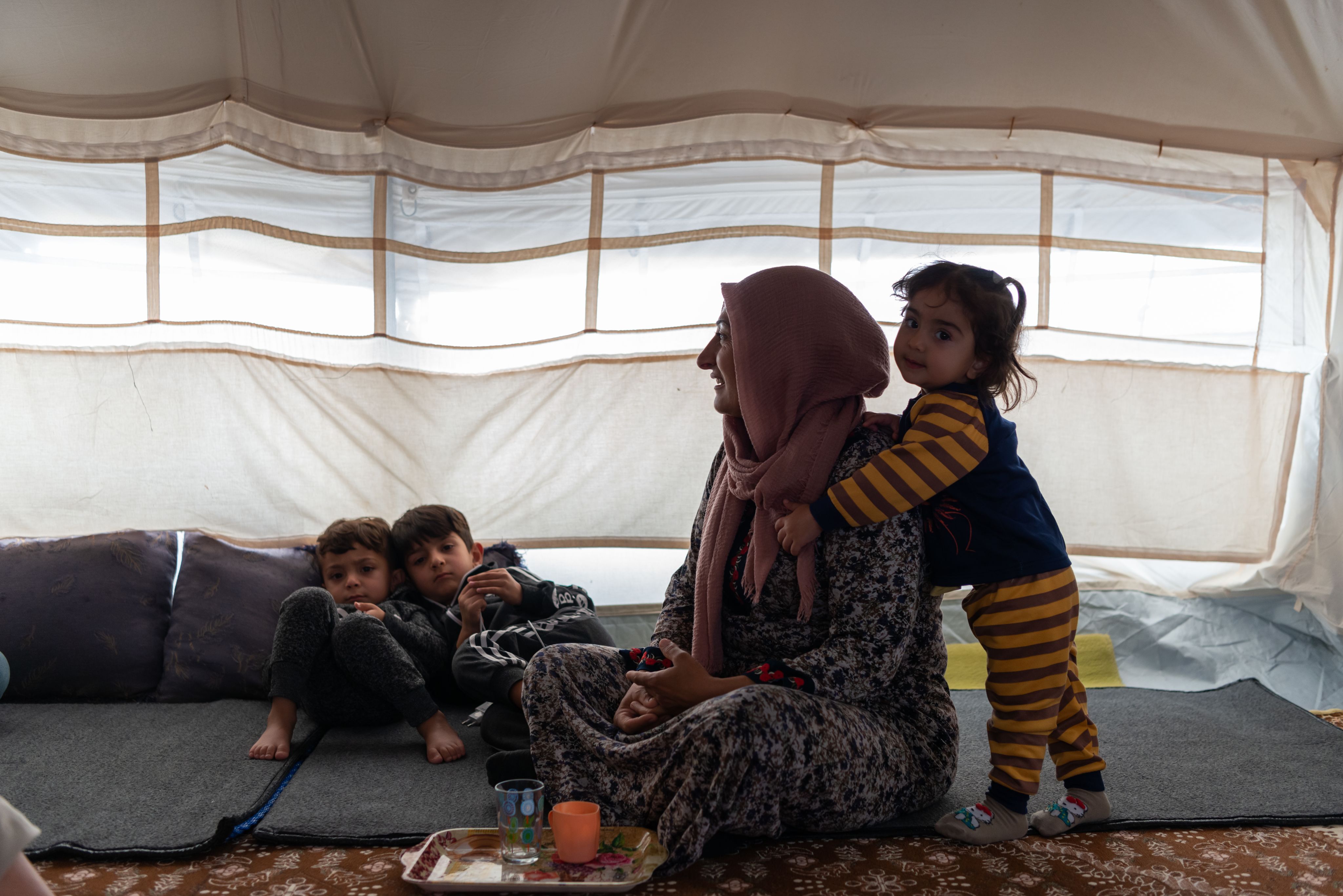 Child holds her mother around the chest.