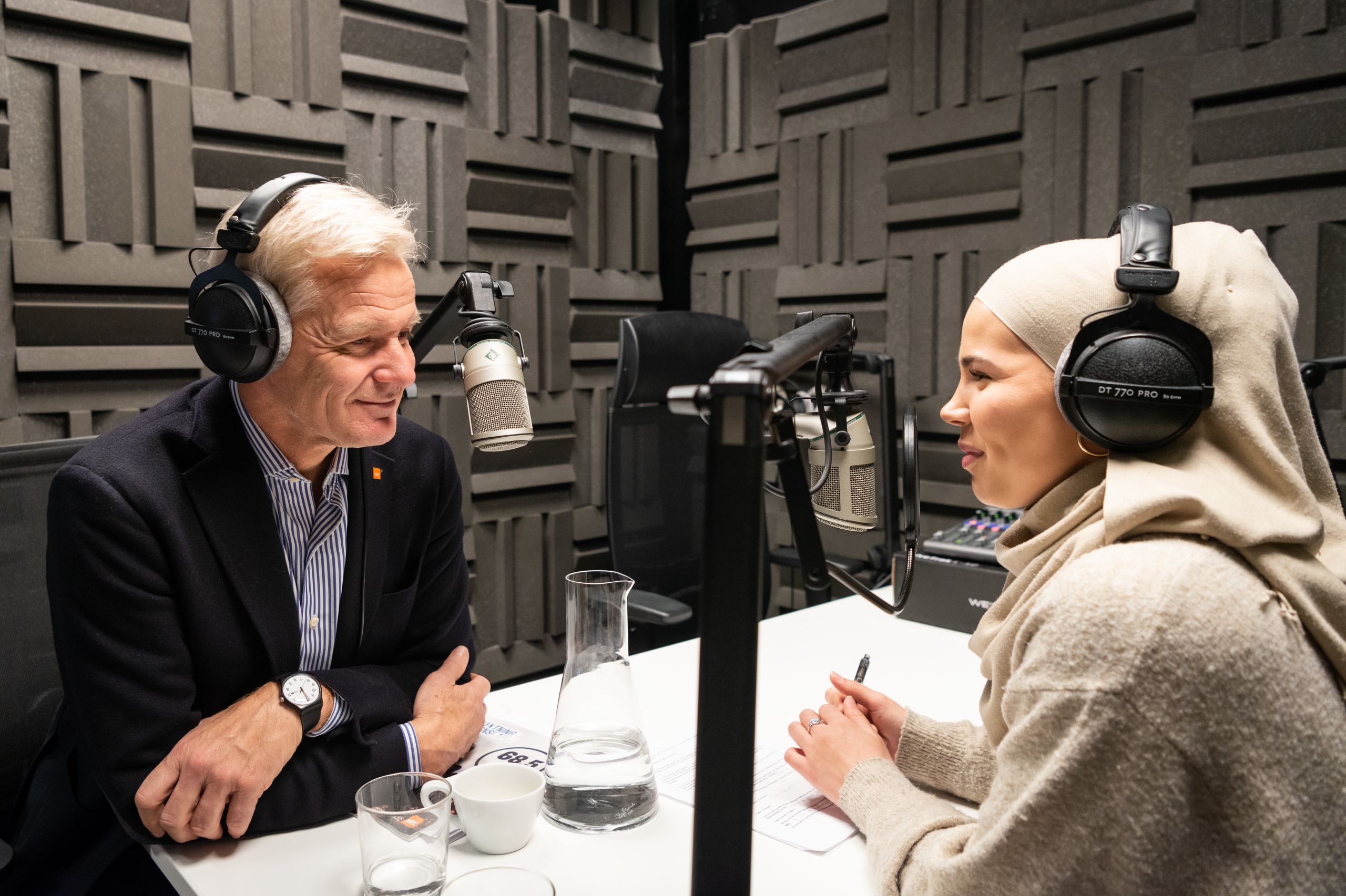 Iman Meskini og Jan Egeland med hvert sitt headset og mikrofon - de spiller inn podkast.