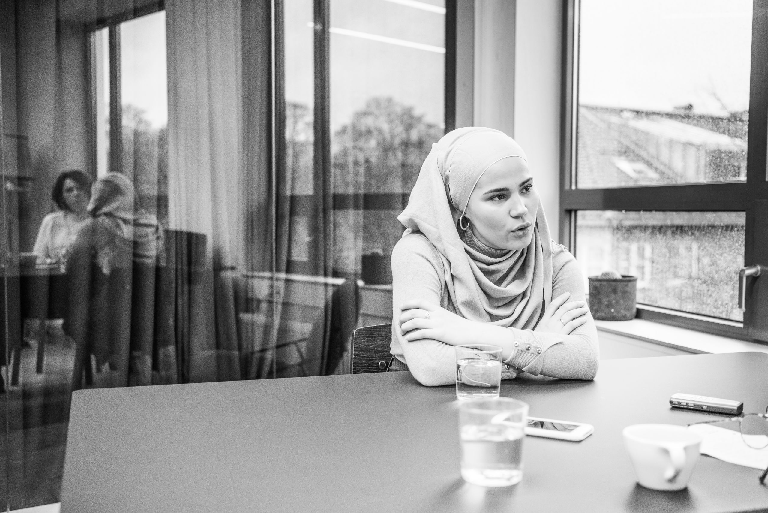 Iman Meskini lener seg over et bord og prater med journaliten.